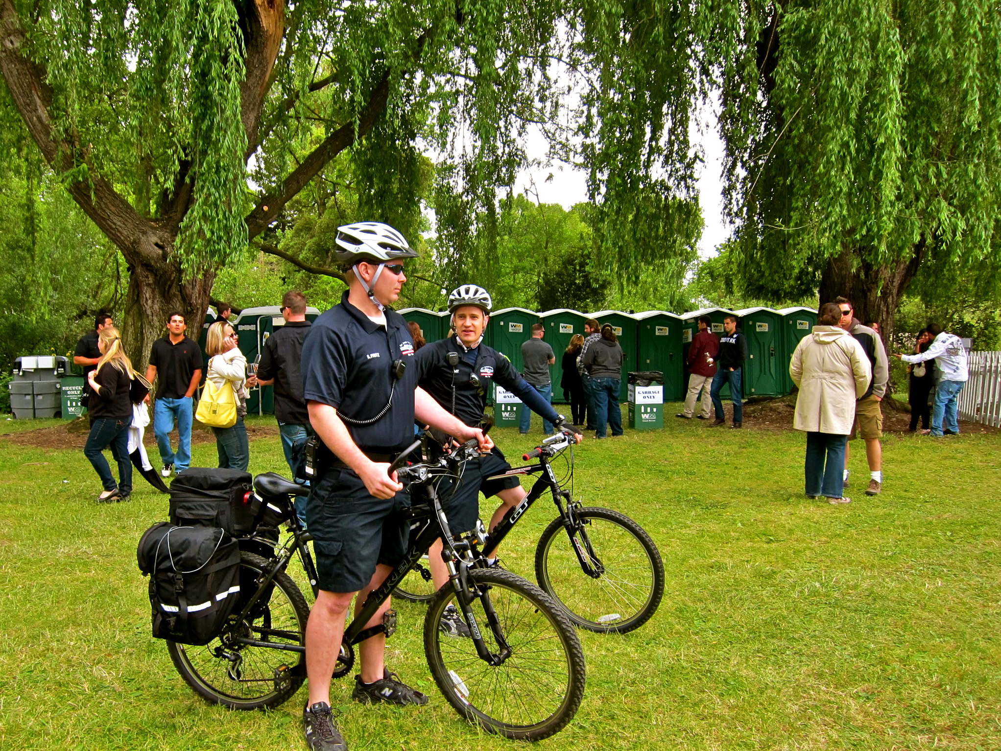Cyclists with helmets and bikes at a Lodi Winegrape Commission event in a park setting.