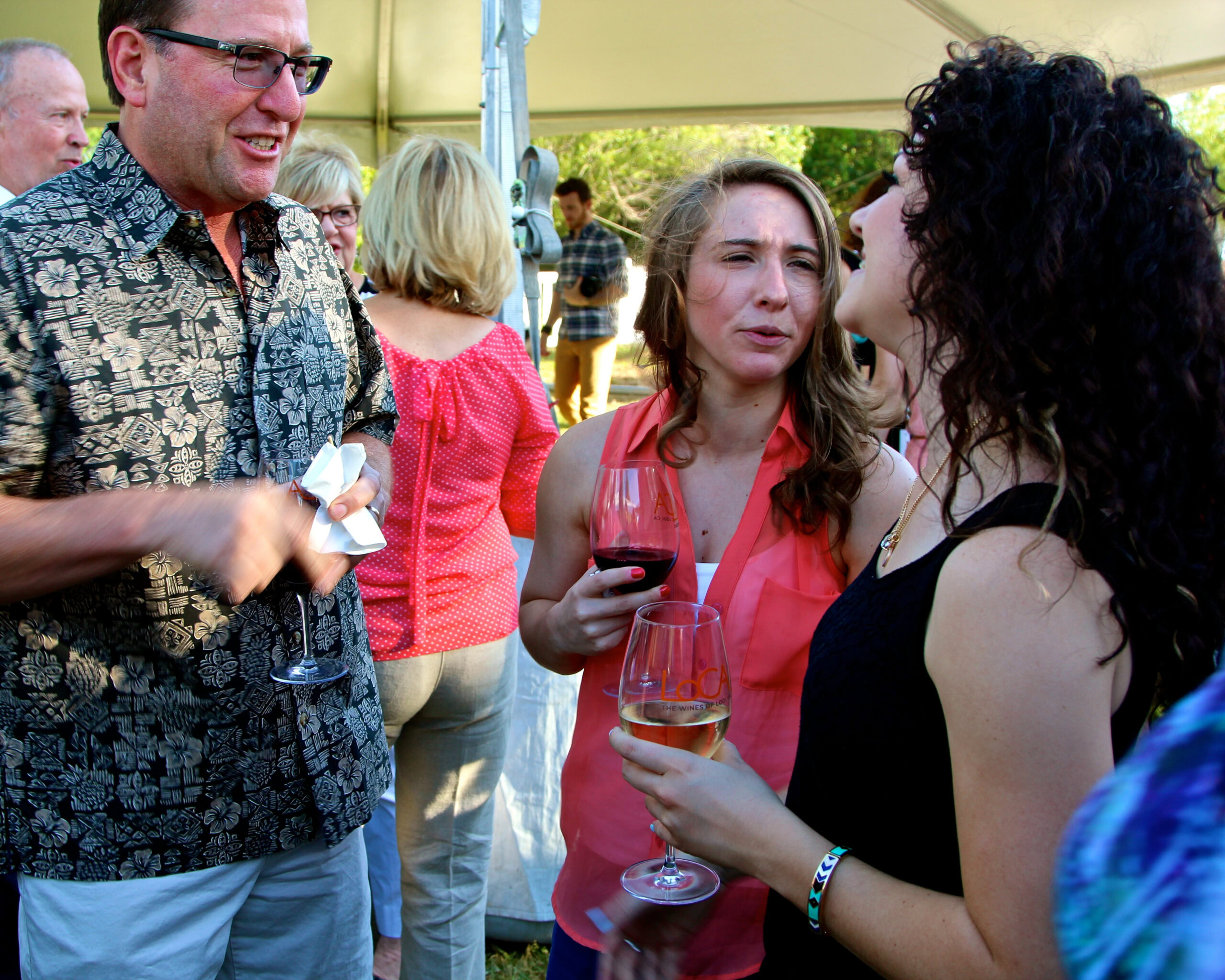 People enjoying wine tasting at Lodi Winegrape Commission event outdoors.