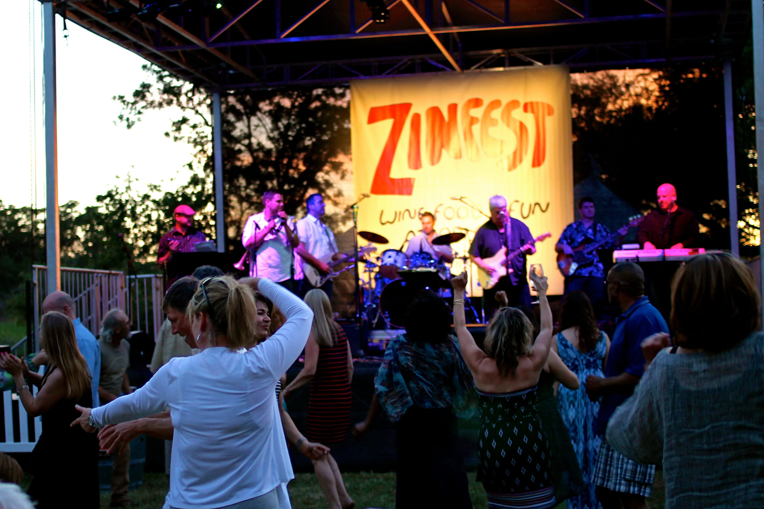 Live outdoor music performance at Zinfest festival in Lodi Wine Country with audience dancing and enjoying the event.