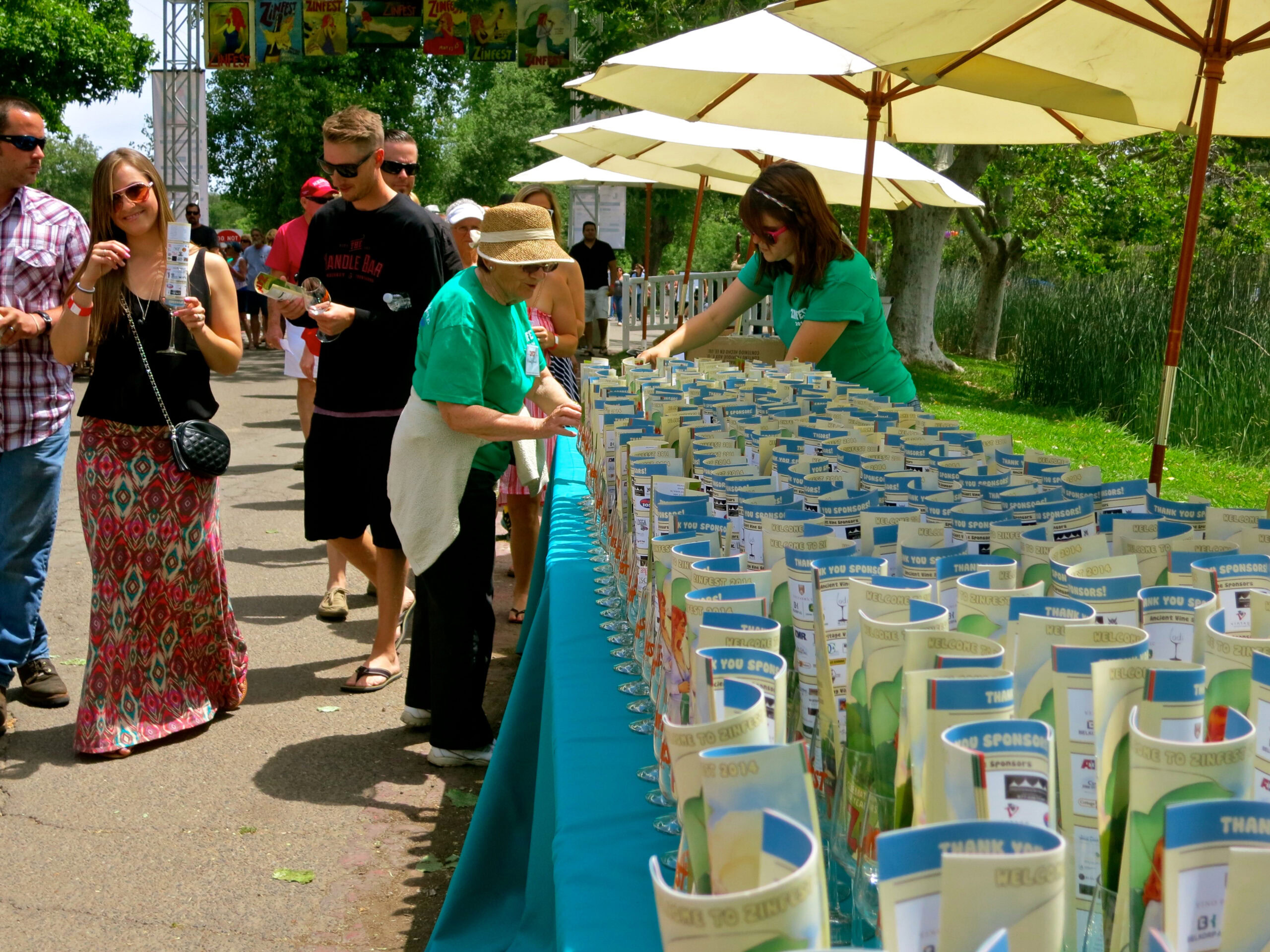 Visitors at Lodi Winegrape Commission tasting event with tables of wine samples and outdoor setting.
