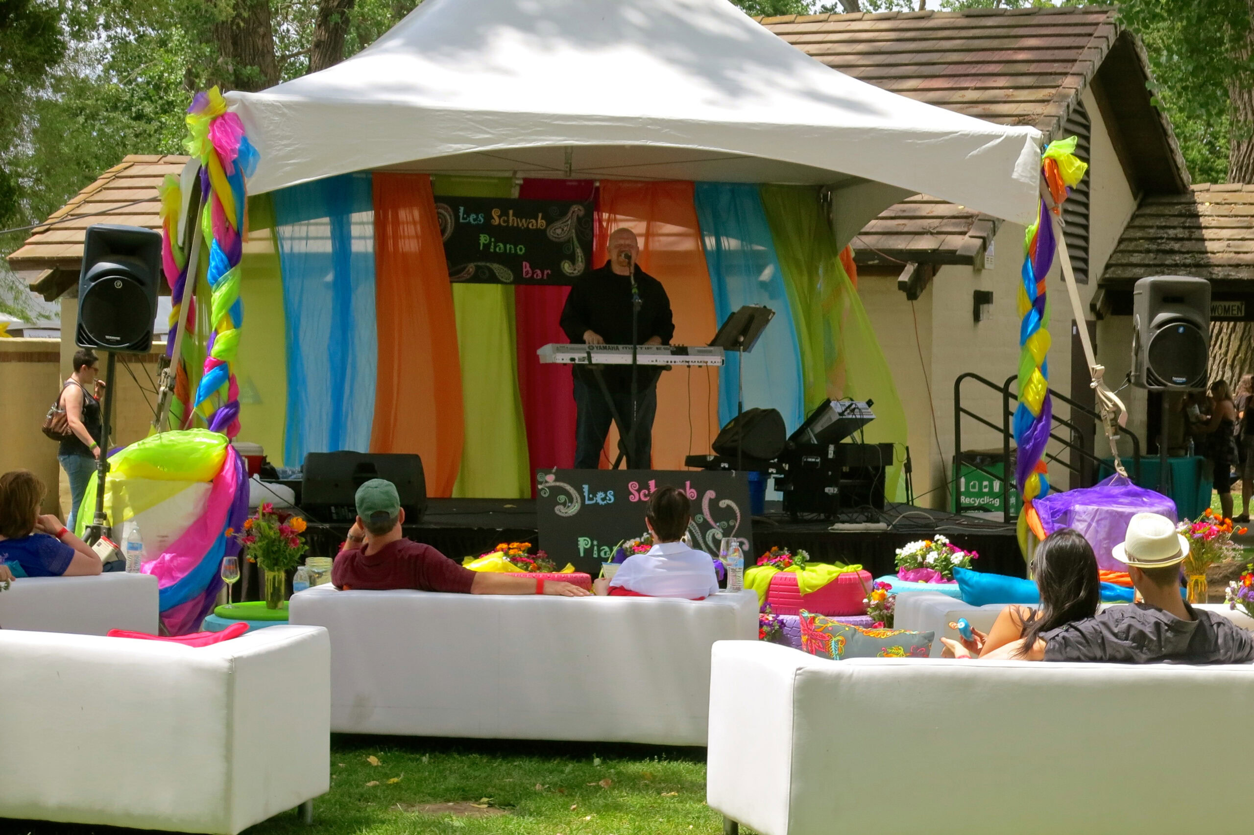 Outdoor event with a stage, colorful decorations, and audience at Lodi Winegrape Commission.