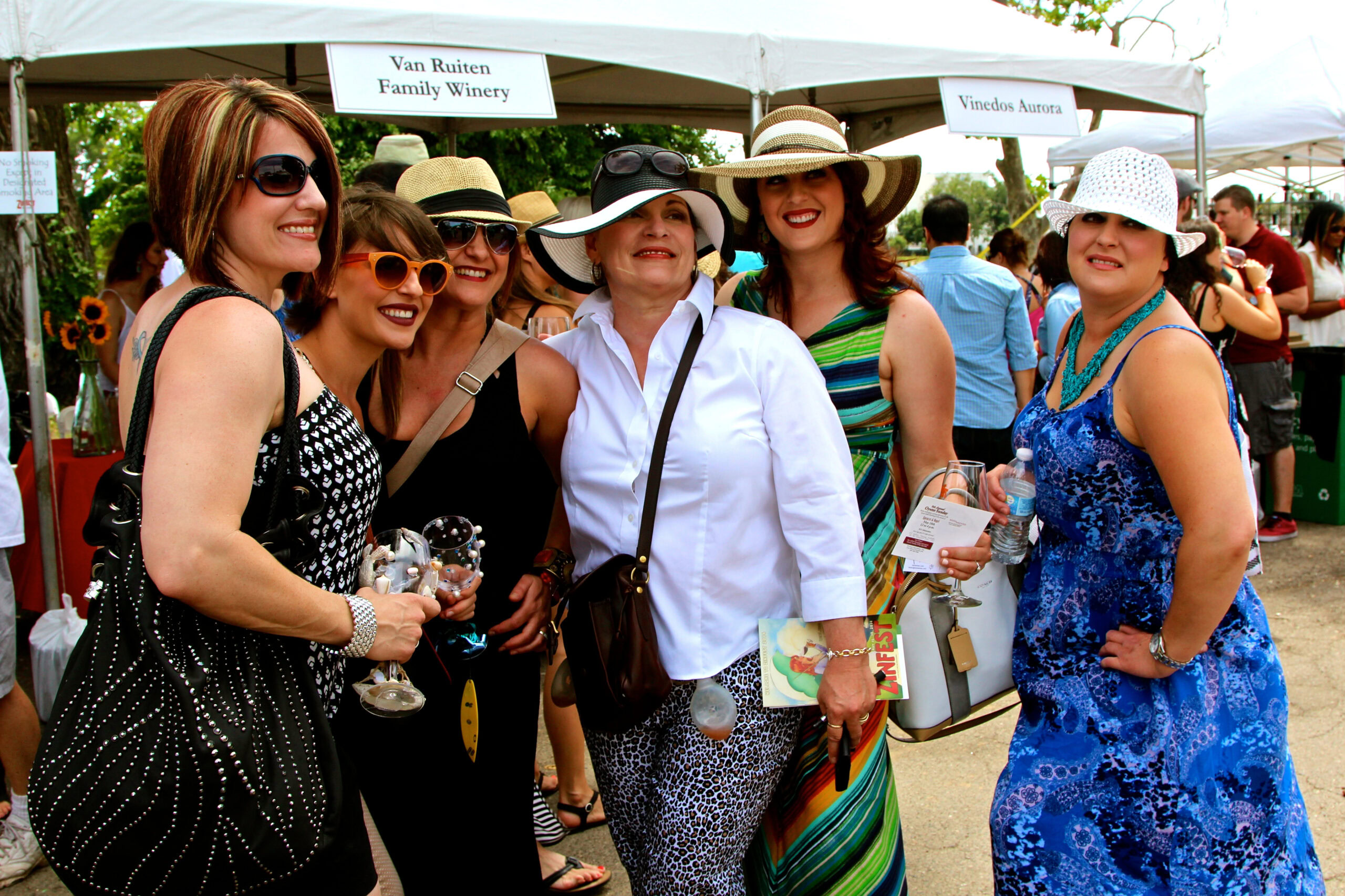Group of women enjoying wine tasting at Lodi Winegrape Commission event outdoors.