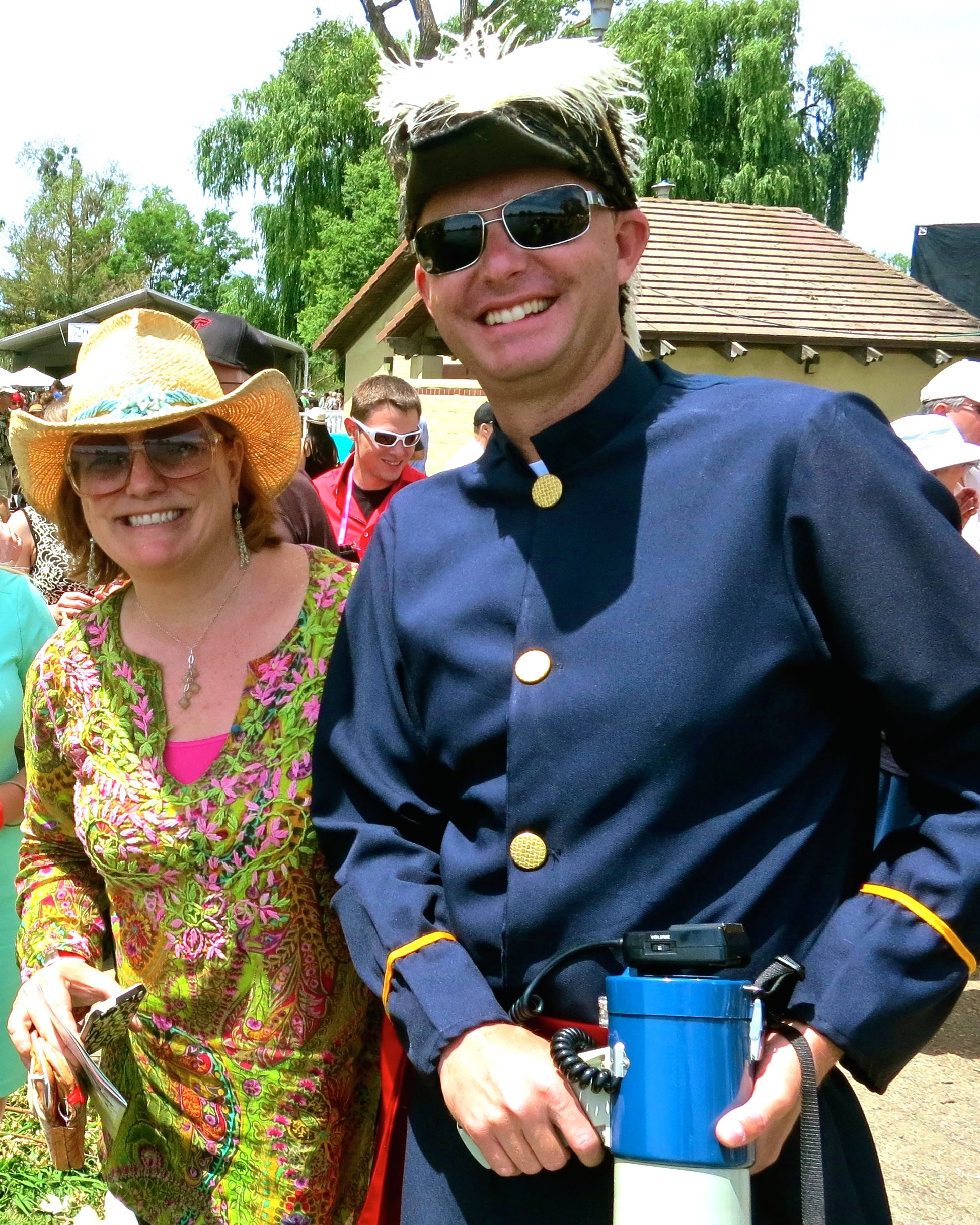 Smiling man in vintage military uniform at Lodi Winegrape Commission event with woman in colorful dress and straw hat.