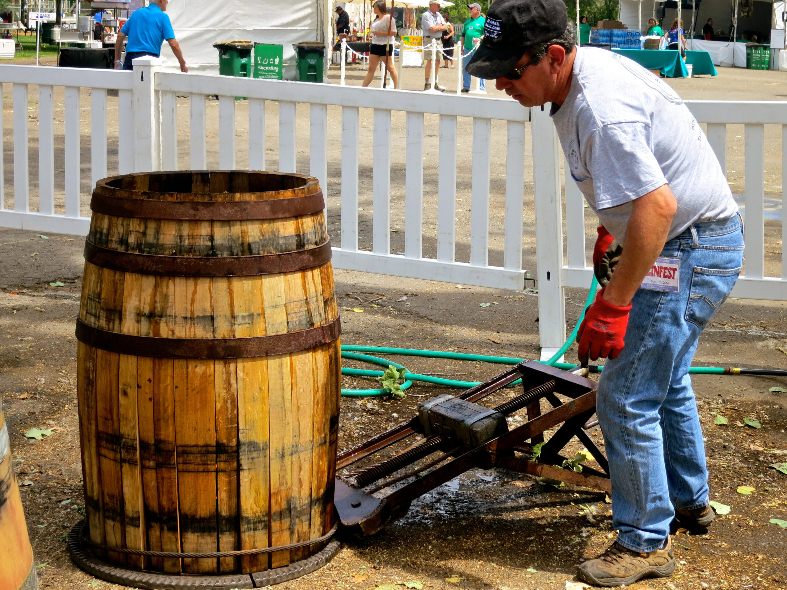 Worker using a grape press at a Lodi winegrape harvest event in California.