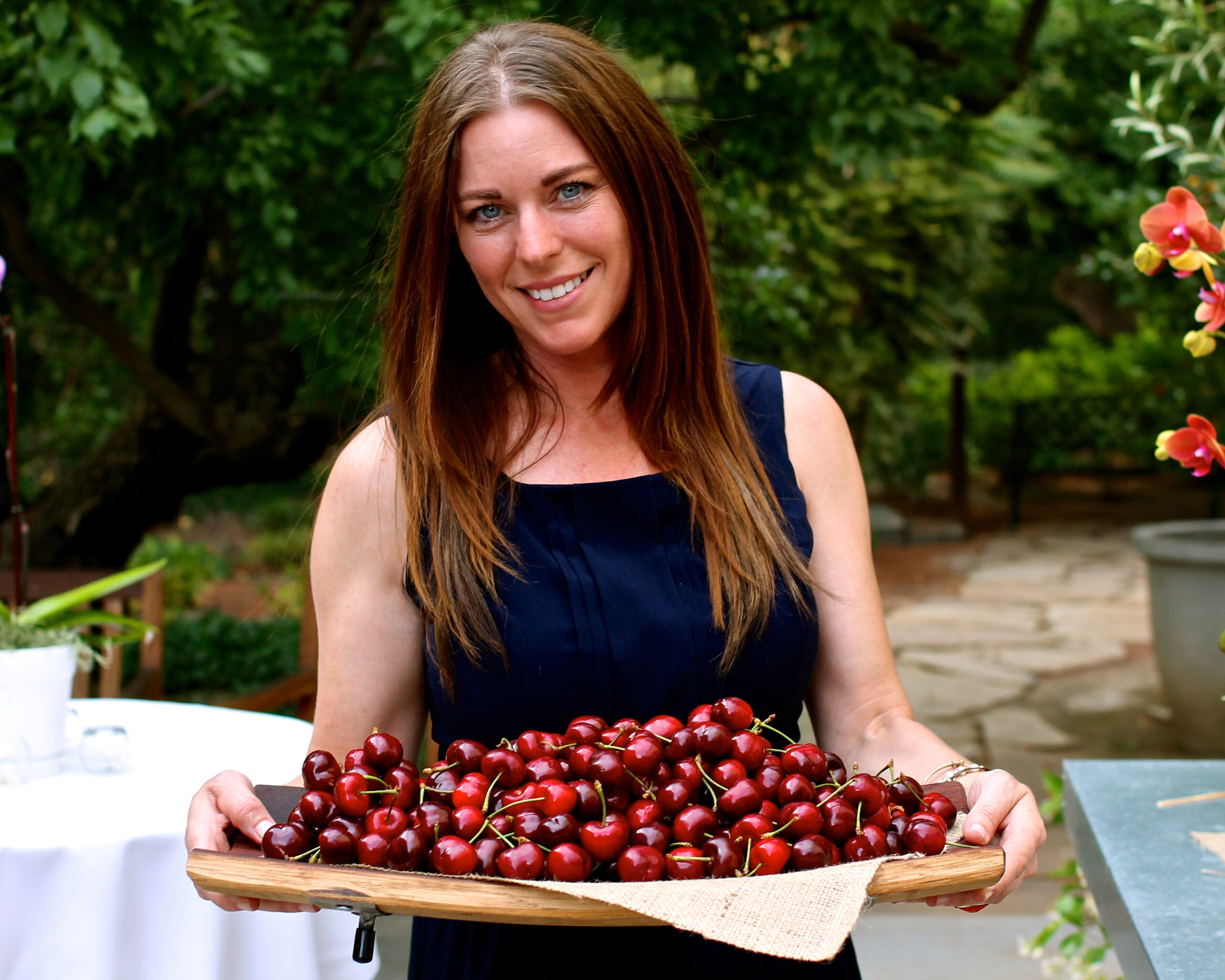 Woman holding a tray of fresh cherries at Lodi Winegrape Commission event.