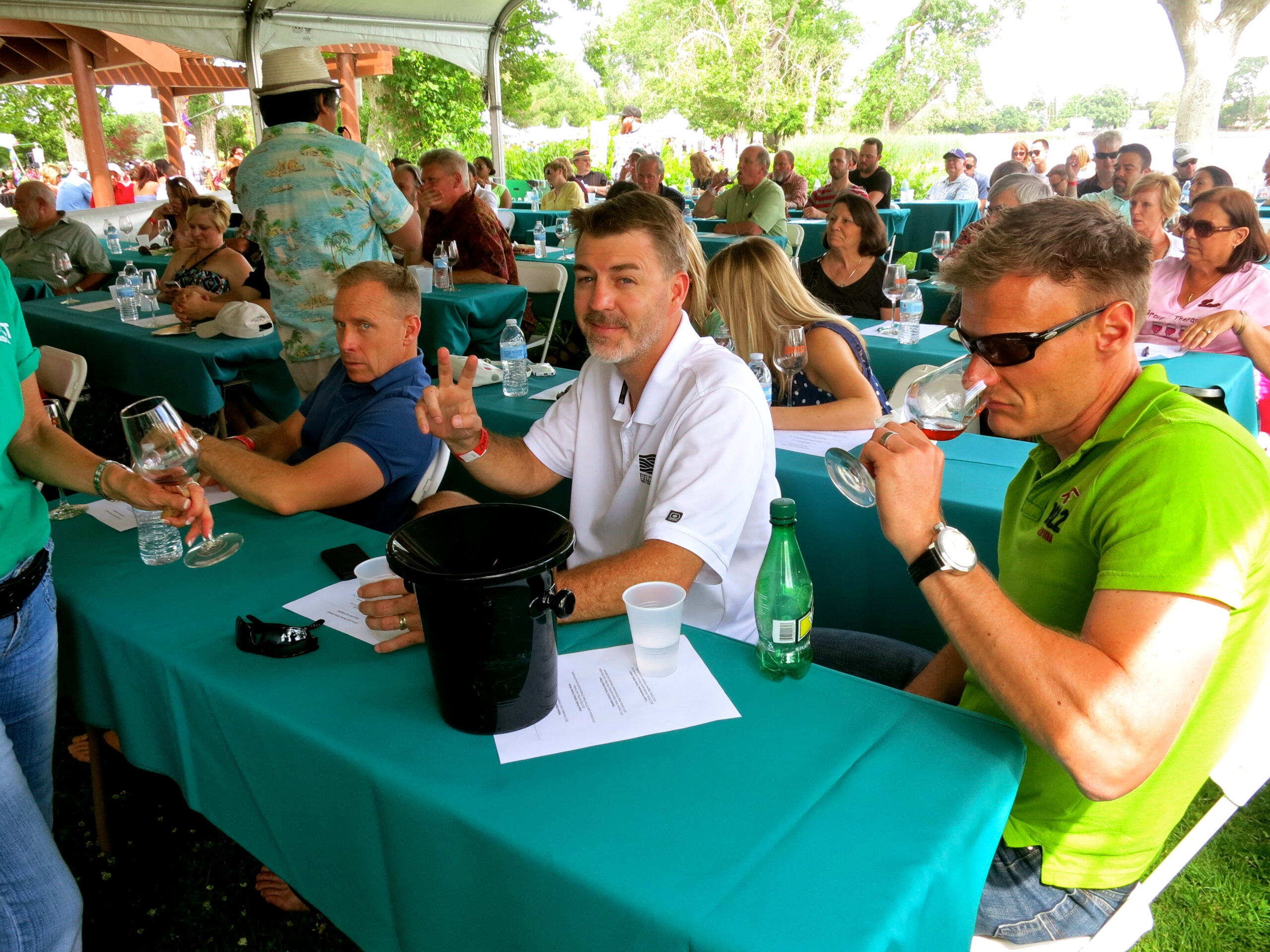 Attendees at a Lodi Winegrape Commission event tasting wine outdoors under a tent.