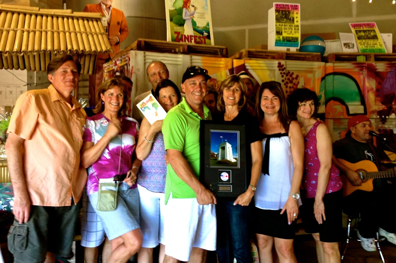Group of people celebrating at Lodi Winegrape Commission event with awards and music.