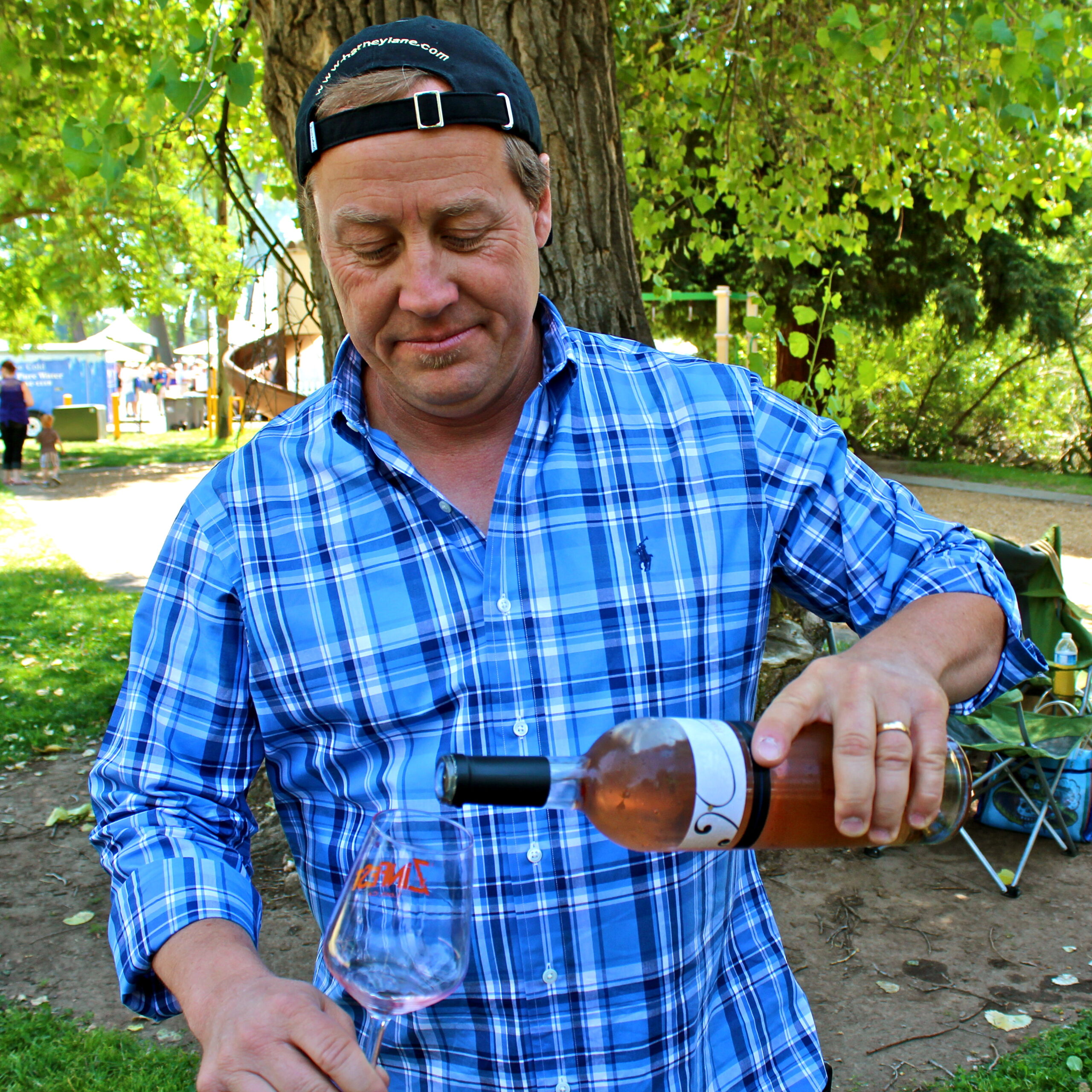Man pouring wine at a Lodi wine event, showcasing local wine culture and vineyards.