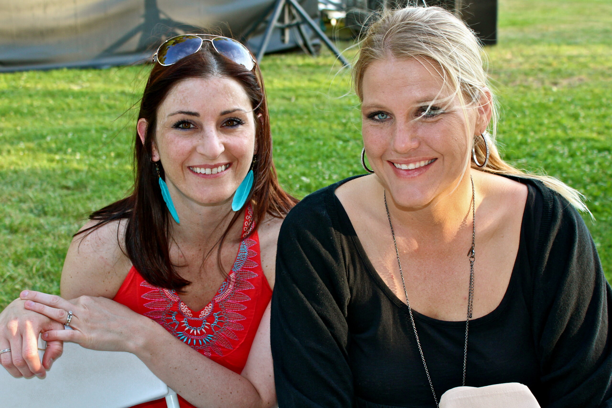 Two women smiling at an outdoor event, representing Lodi Winegrape Commission activities.