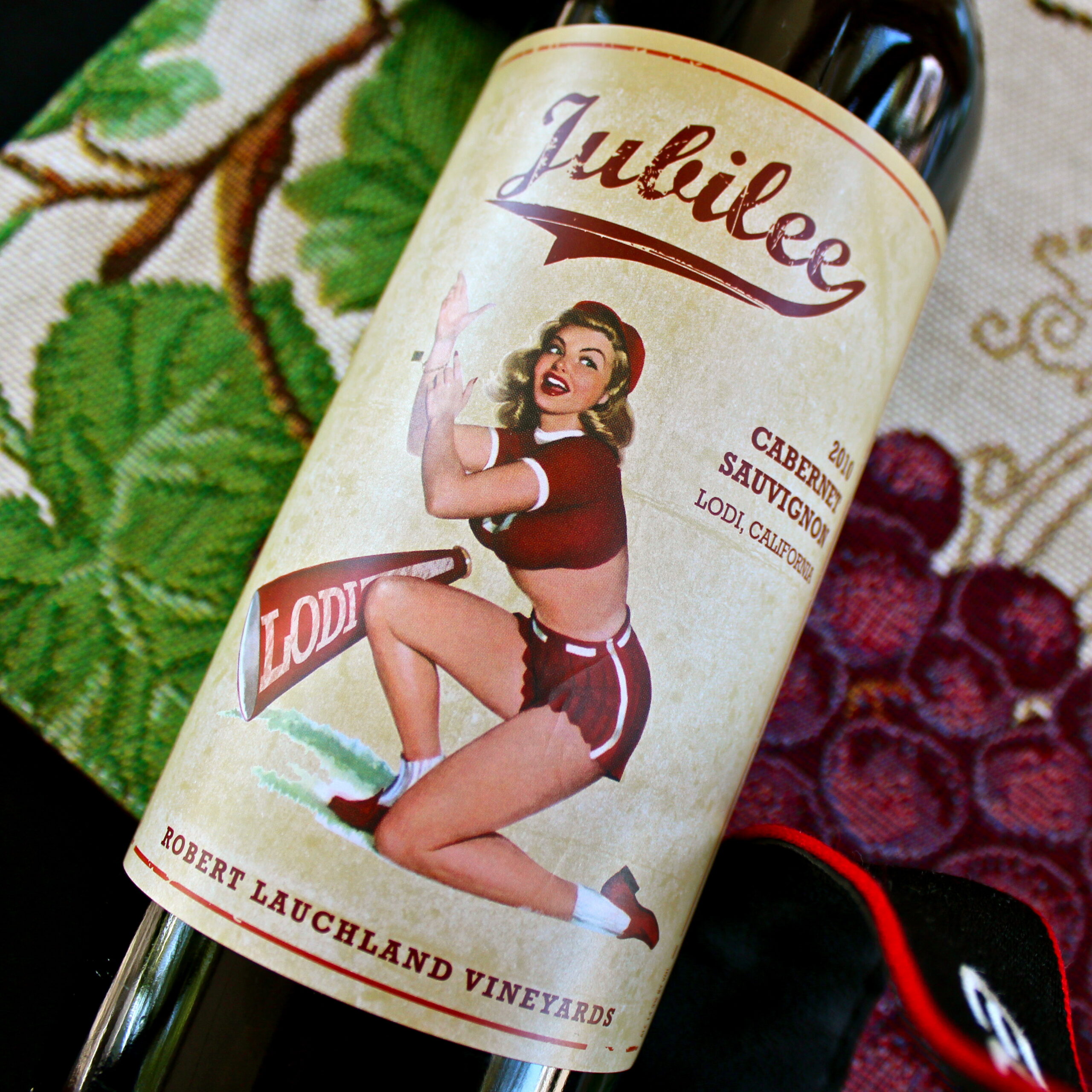 Vintage-style Jubilee wine label featuring a pin-up girl with grapes in the background.