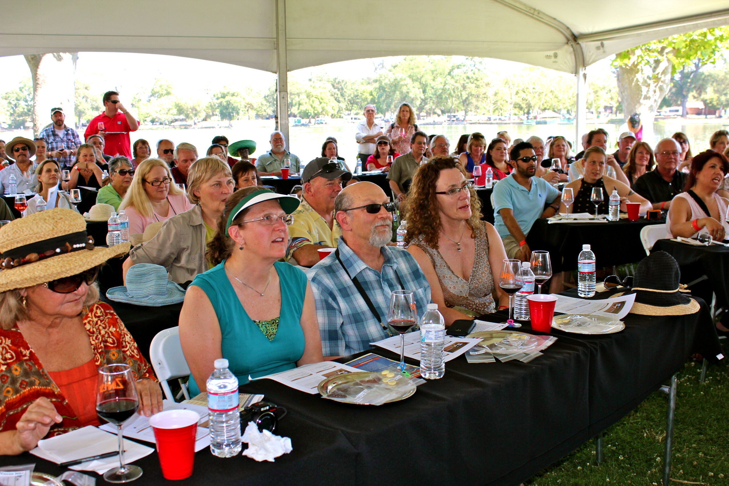 Audience attending a Lodi Winegrape Commission event outdoors under a large tent.