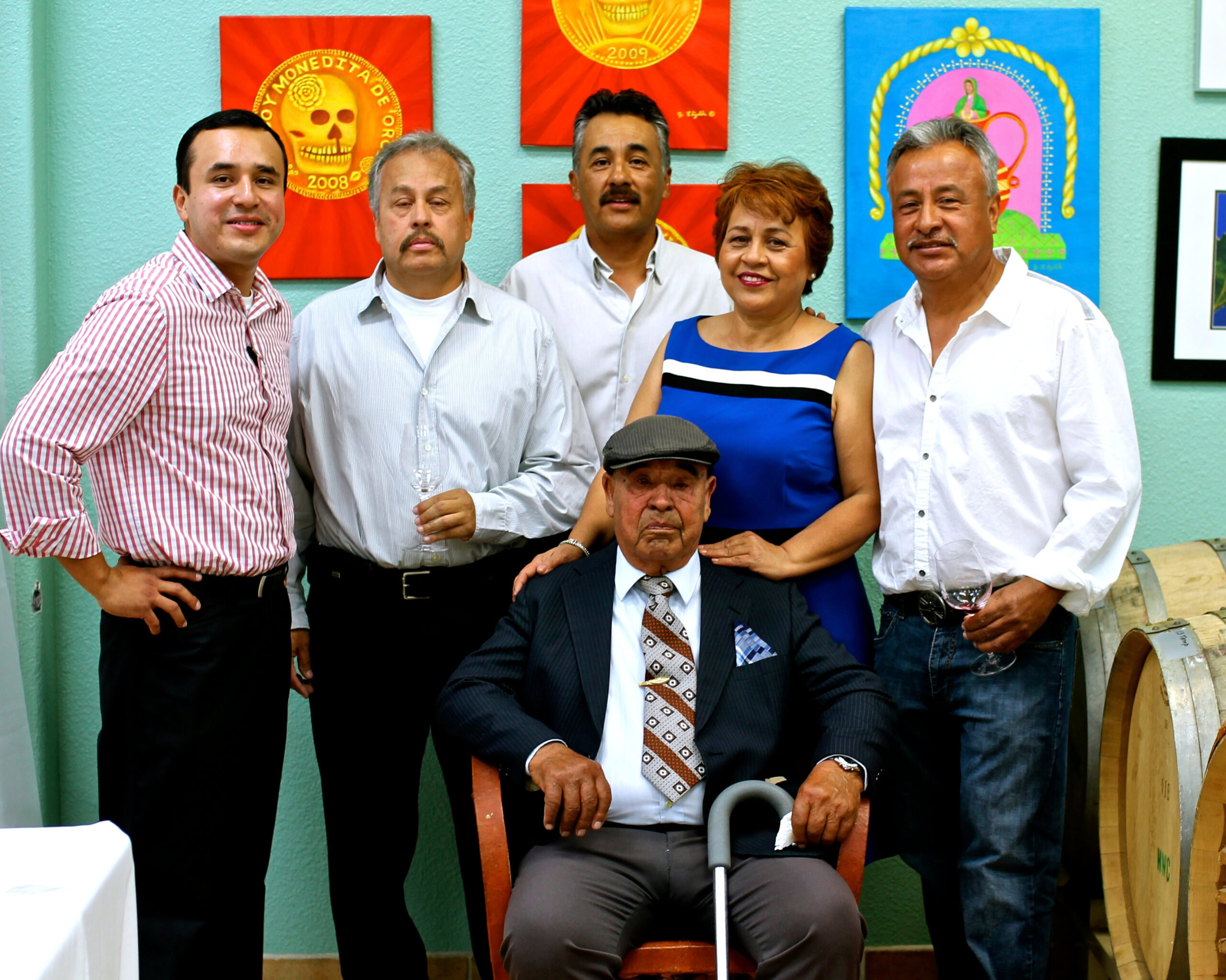Group photo of Lodi Winegrape Commission members at an event, with colorful wine-themed artwork in the background.