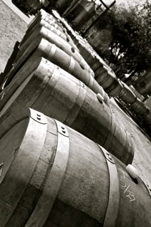 Rows of wine barrels stored outdoors at a vineyard in Lodi, California, showcasing wine aging process.