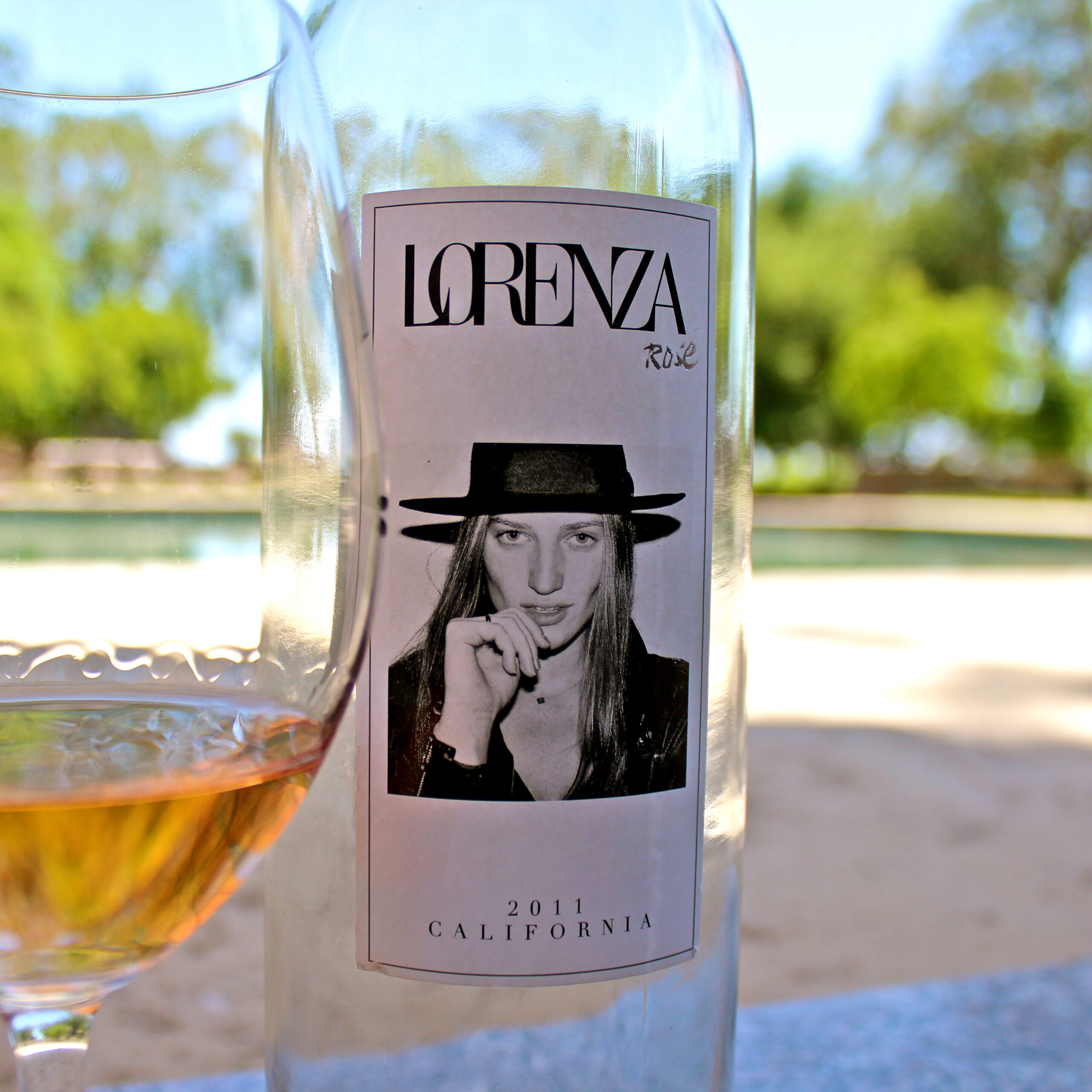 Close-up of a wine bottle label featuring a woman with a hat, California 2011, outdoors setting.