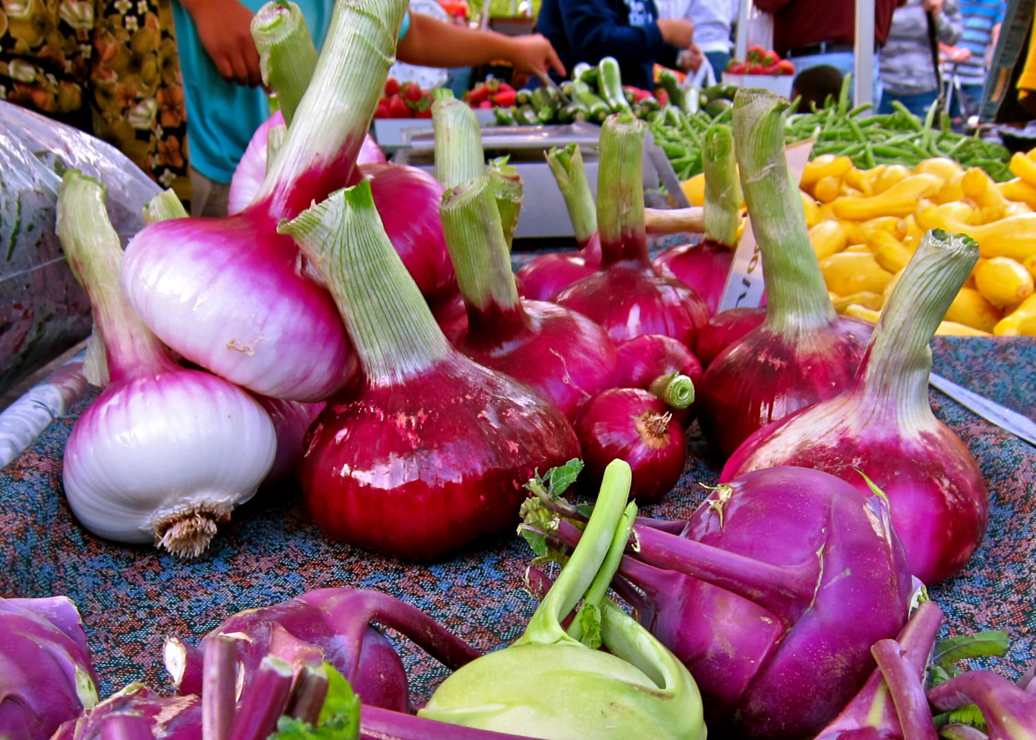 Fresh onions and vegetables at Lodi Winegrape Commission market for local wine and produce.