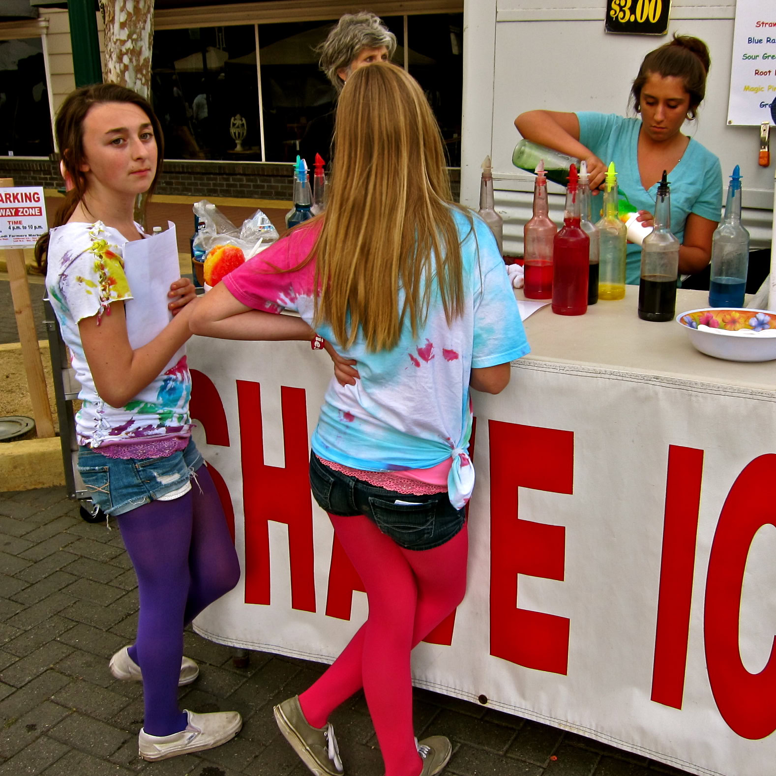 Young girls at a Lodi wine event, engaging with a wine tasting booth, showcasing local wine culture.