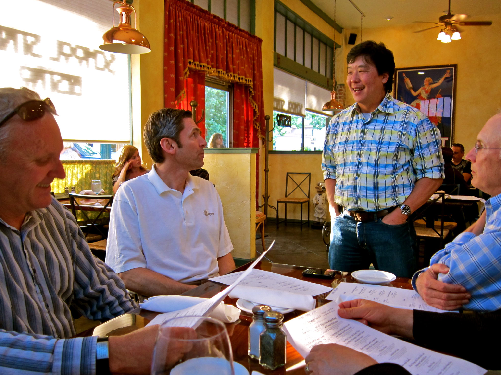 Group of people in a restaurant discussing wine and grape industry in Lodi, California.