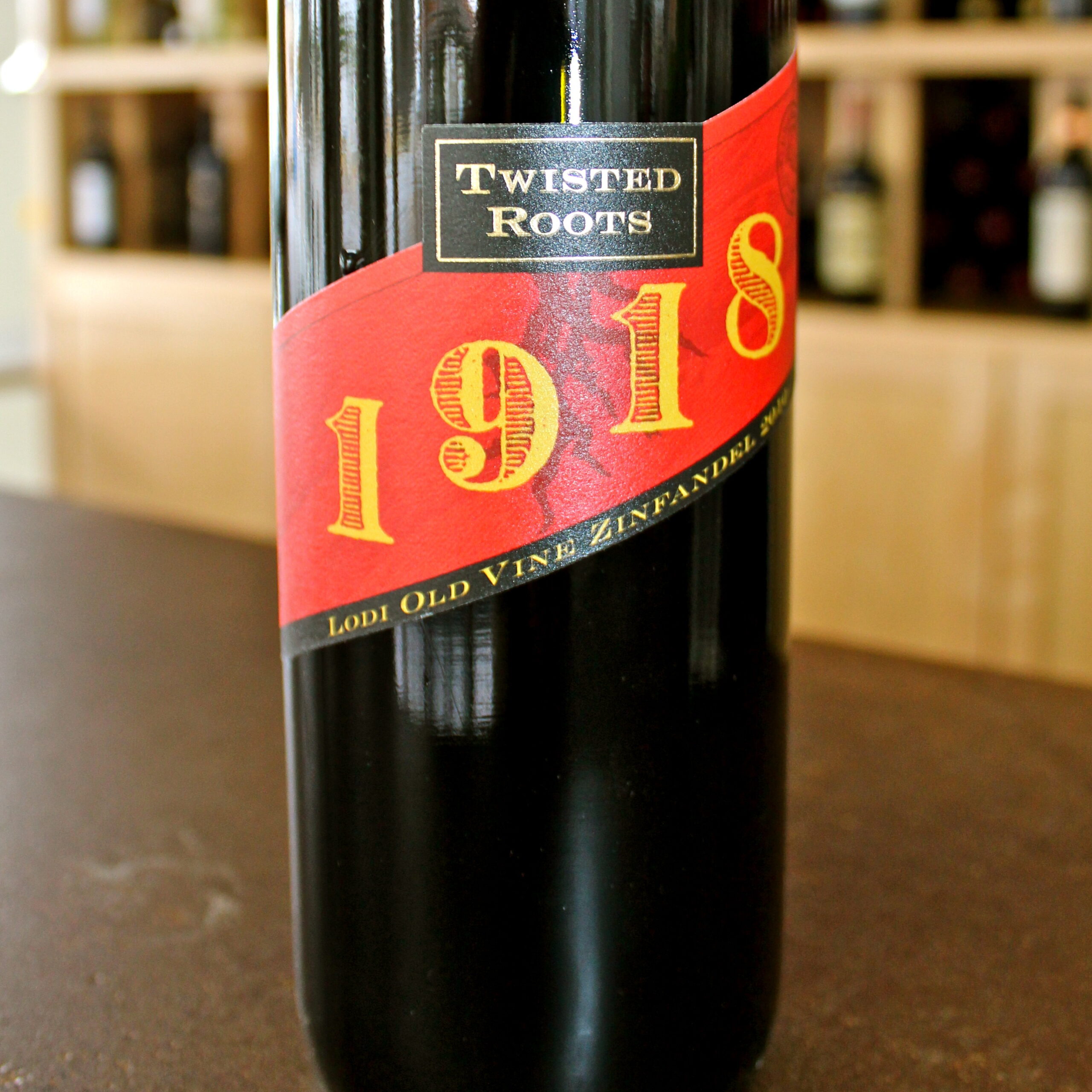 Bottle of Twisted Roots 2018 wine from Lodi Winegrape Commission, showcasing a black bottle with red and yellow label.