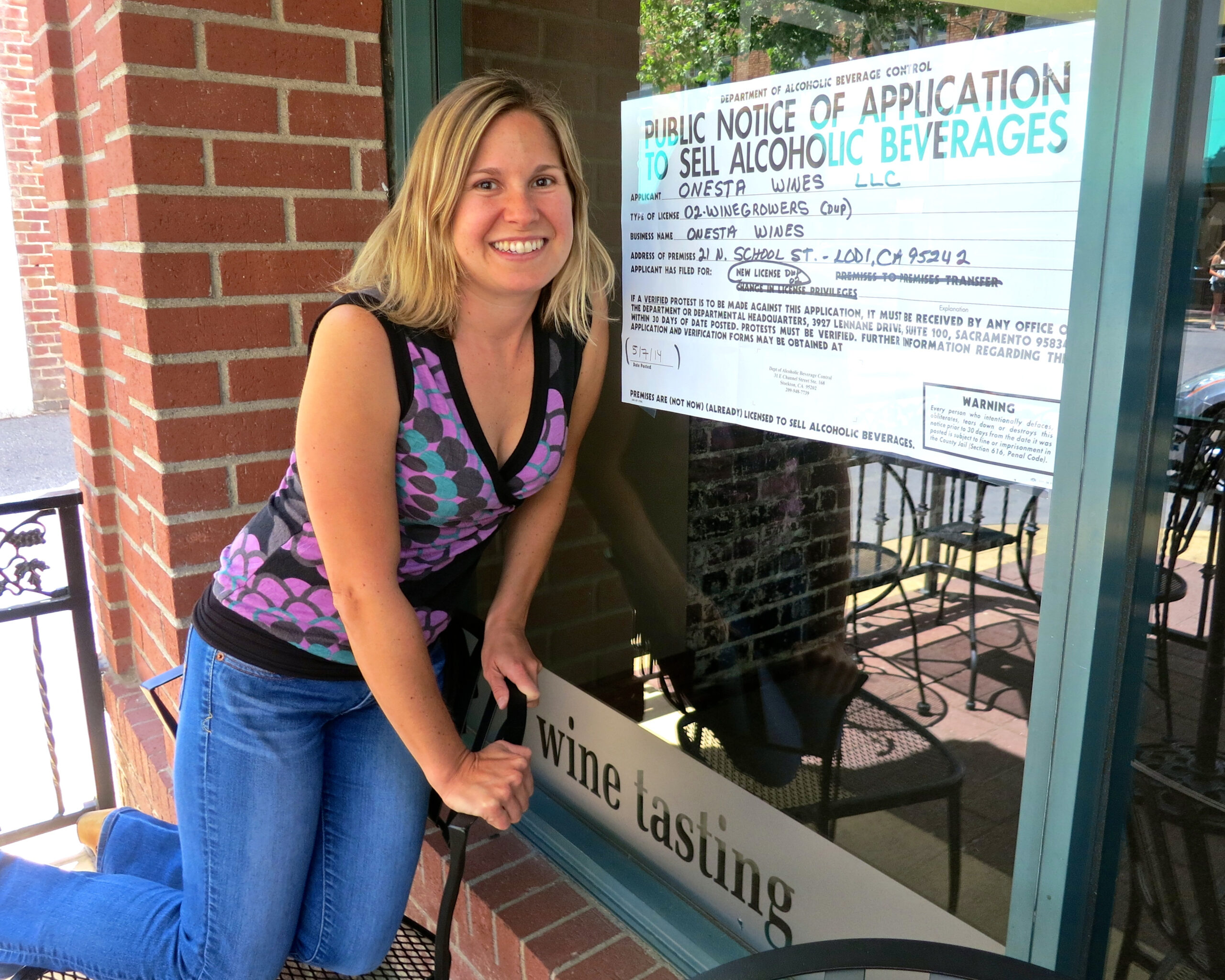 Woman smiling at wine tasting event outside Lodi Winegrape Commission office.