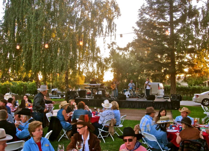 Outdoor event with live band, audience, and string lights at sunset in Lodi, California.