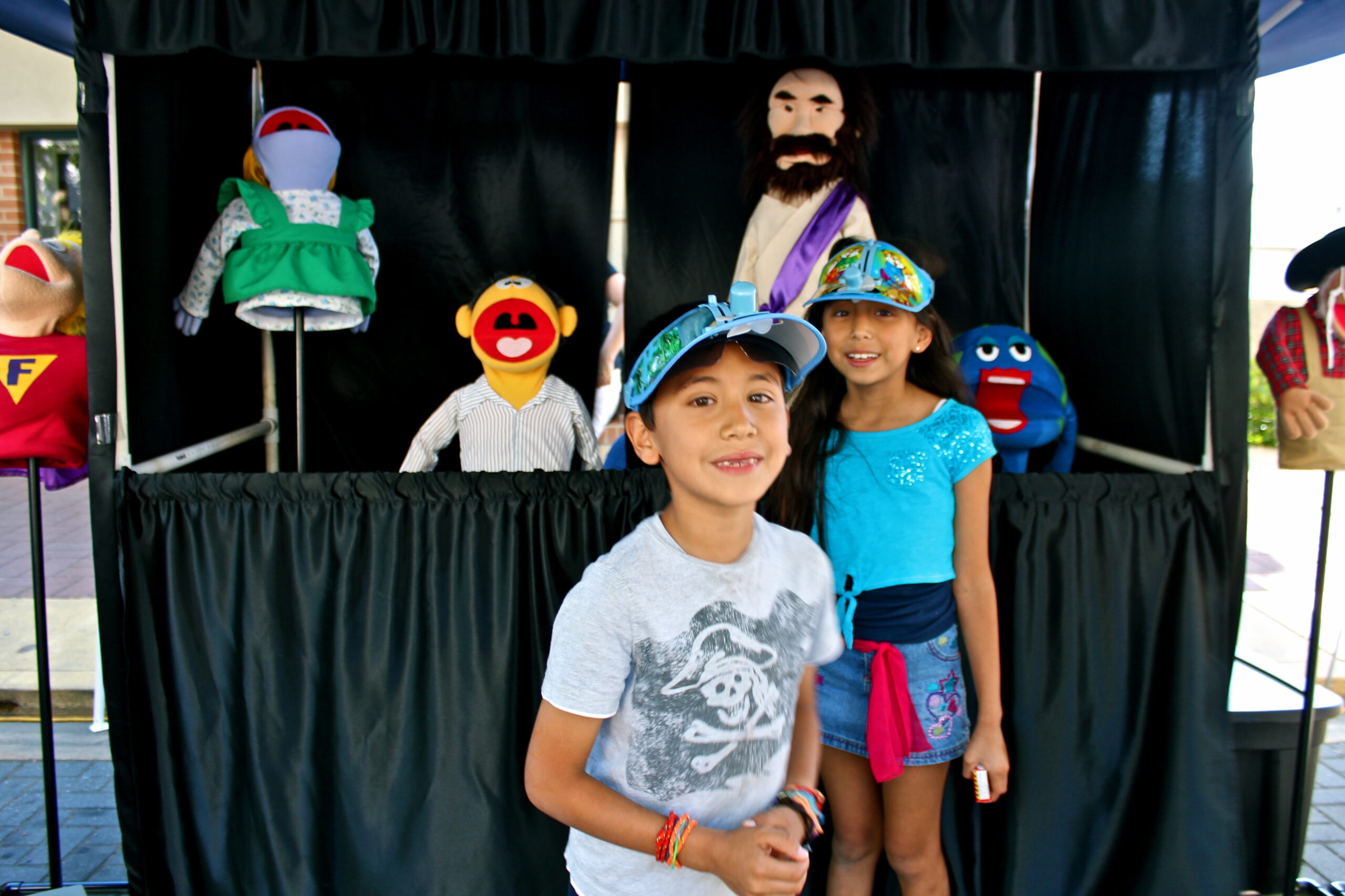 Children at Lodi Winegrape Commission event with puppets and a puppet show backdrop.