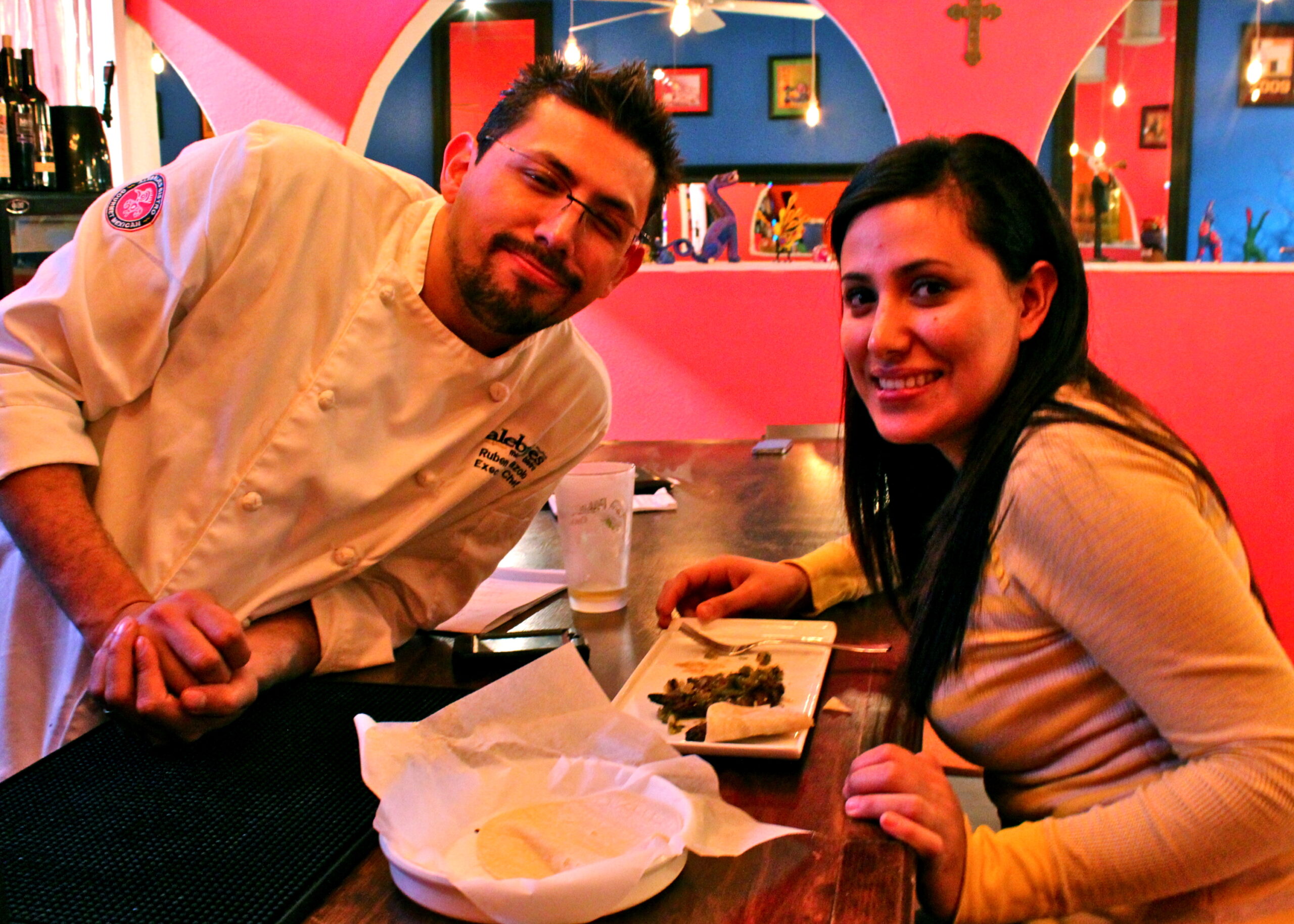 Chef and guest enjoying a meal at a restaurant, promoting Lodi wine and local cuisine.