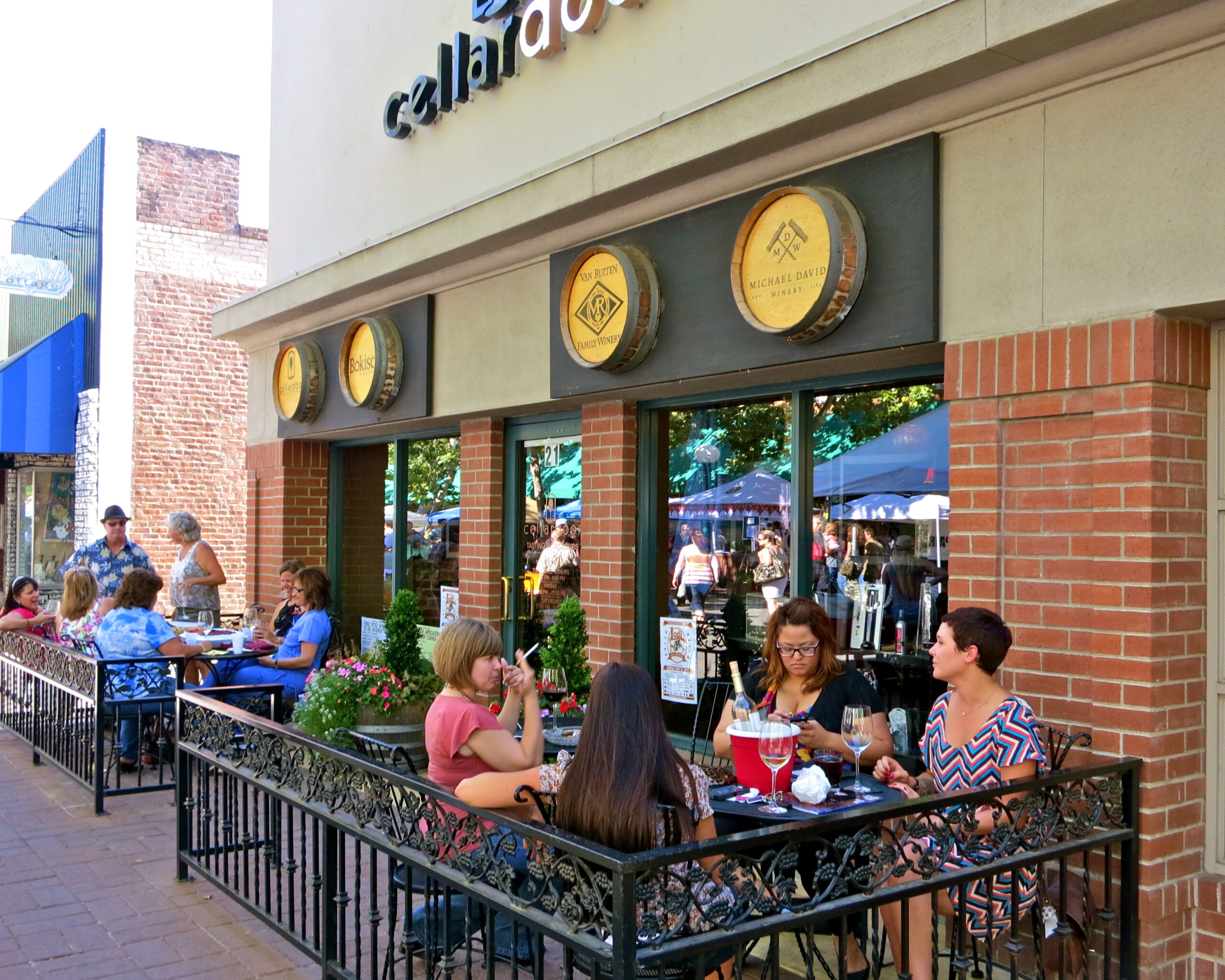 Outdoor seating at Calaveras Wine Bar with customers enjoying wine and food in Lodi, California.