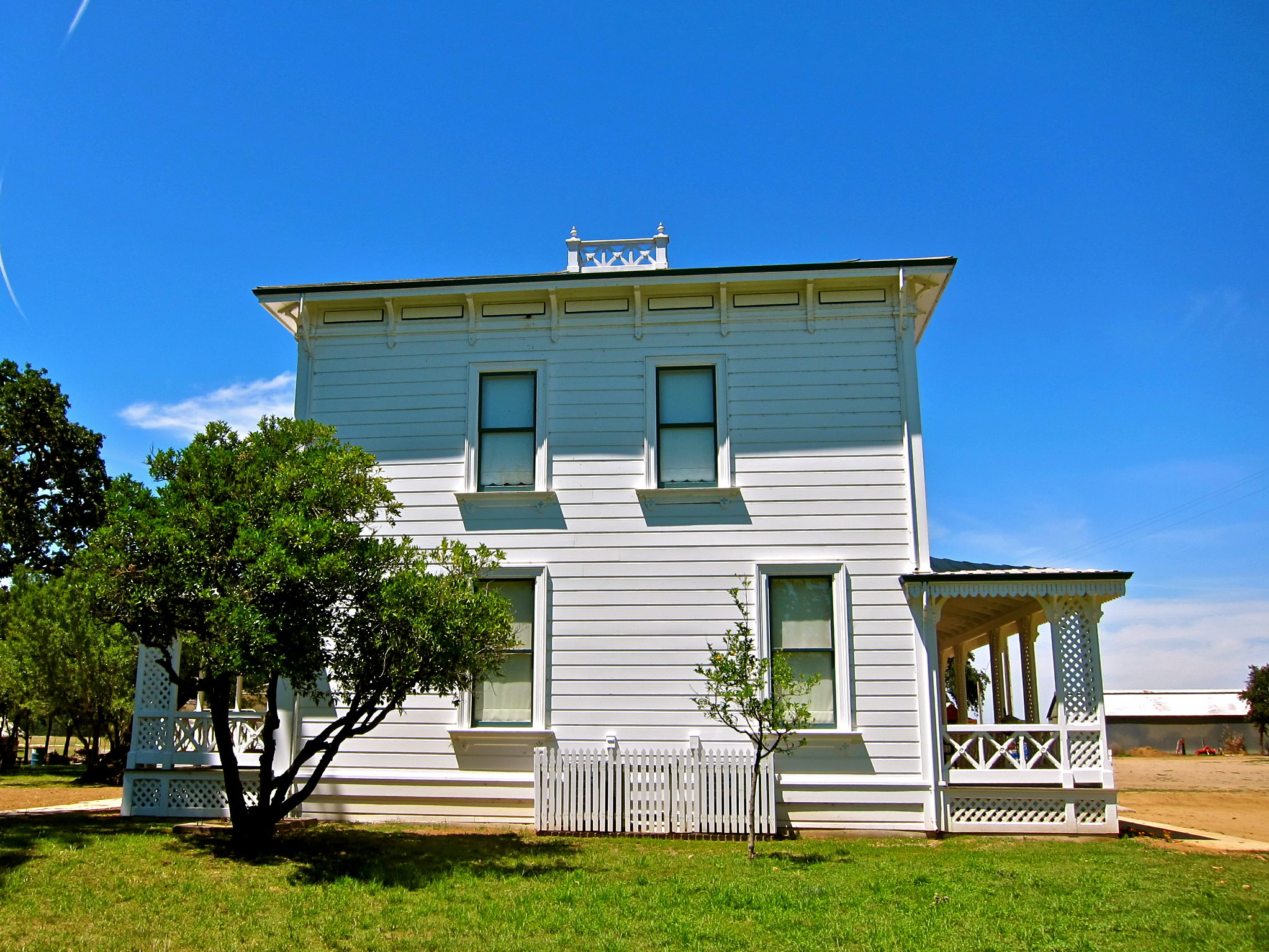 Historic white wooden building with porch and trees in Lodi, California, representing local wine industry heritage.