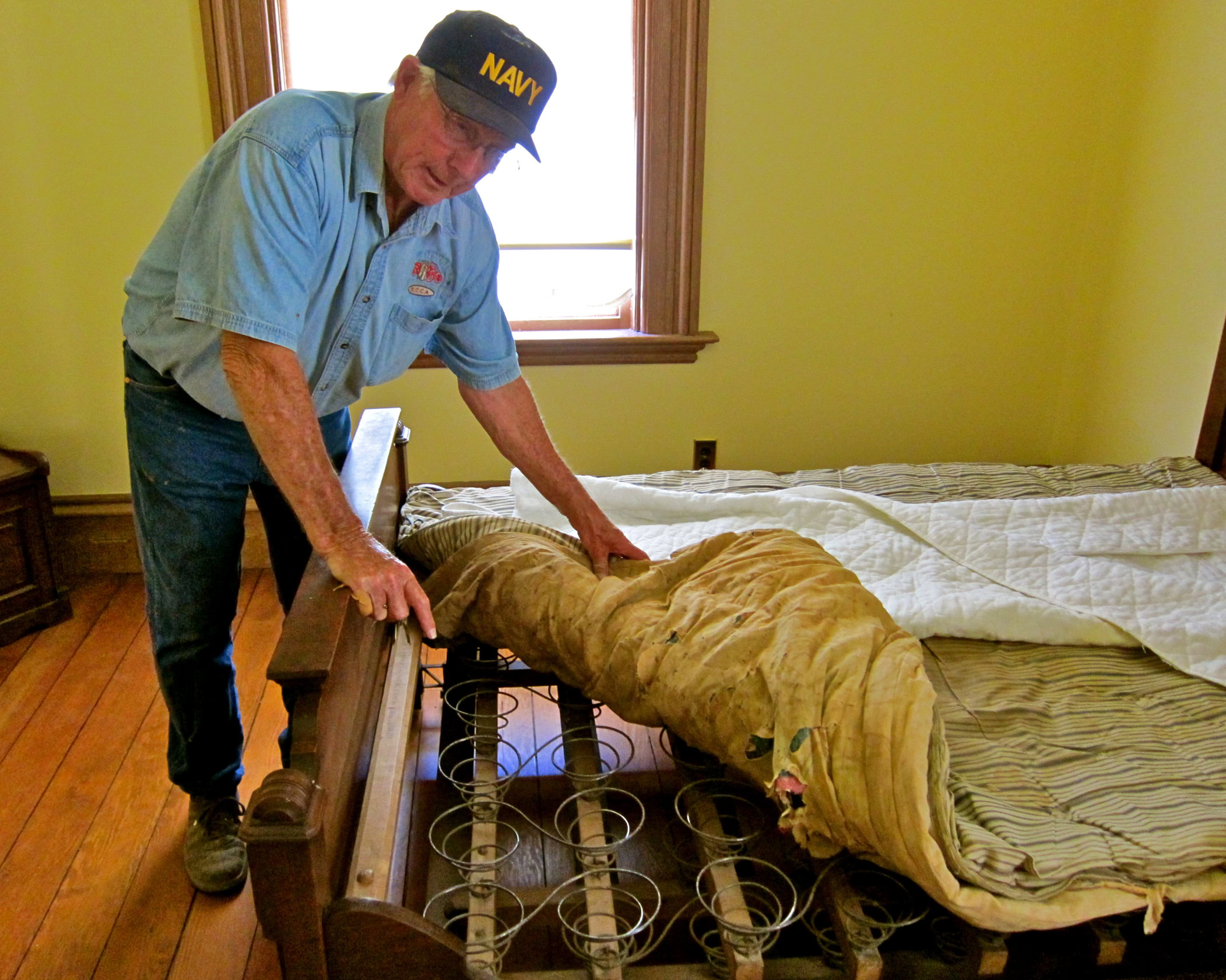 Man inspecting a wine barrel in a cozy room, representing Lodi Winegrape Commission's focus on wine production.