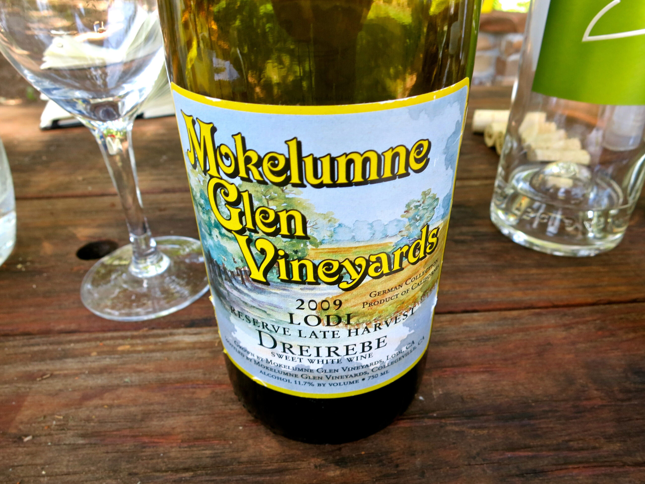 Close-up of Mokelumne Glen Vineyards 2009 wine bottle on wooden table with glasses.