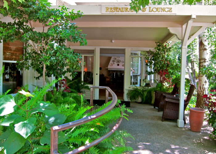 Scenic view of a vineyard tasting room with lush greenery and outdoor seating area in Lodi, California.