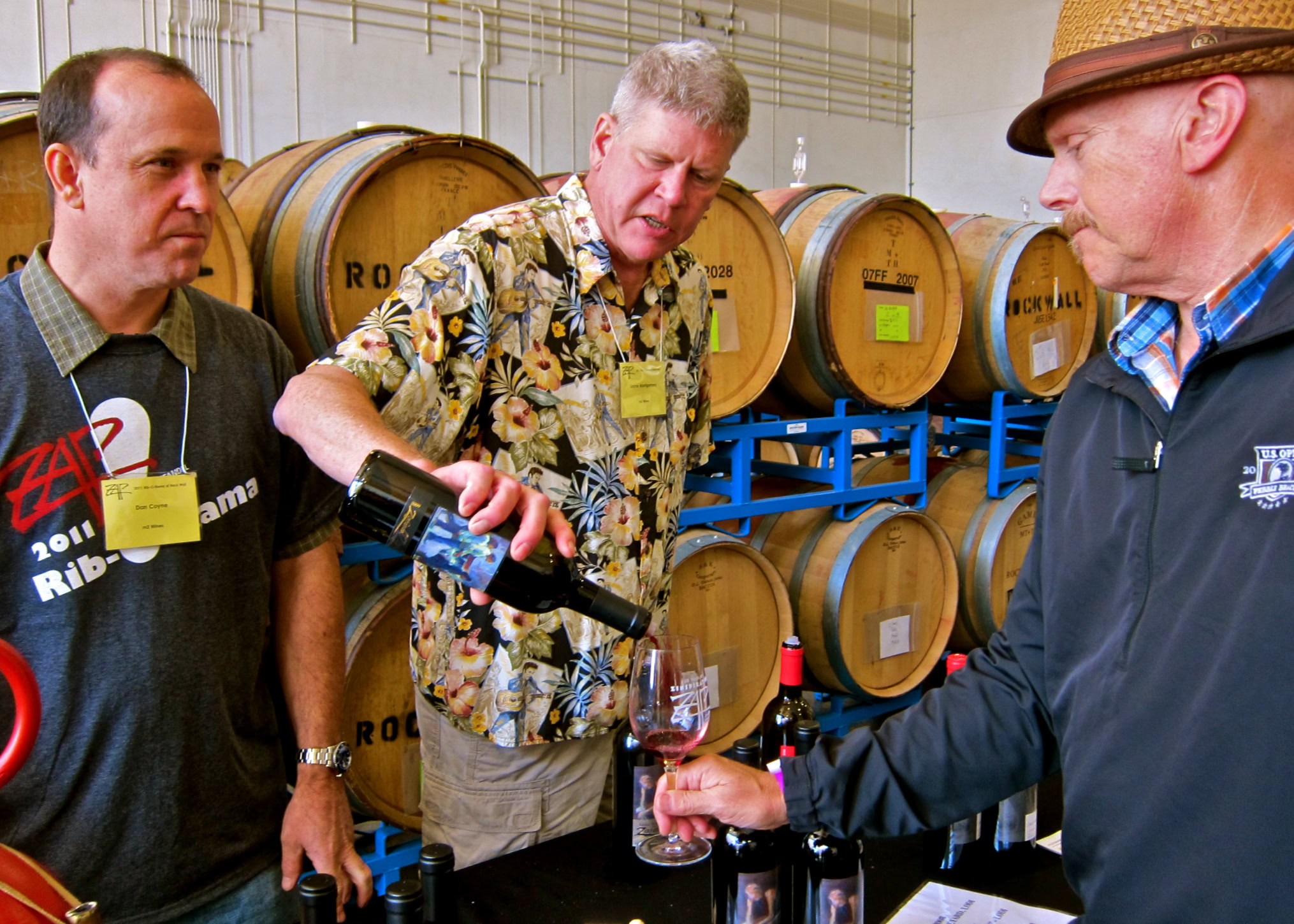 Wine tasting at Lodi Winegrape Commission with barrels in background and participants sampling wine.