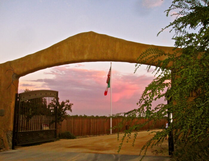 Entrance archway at Lodi Winegrape Commission with California flag at sunset.