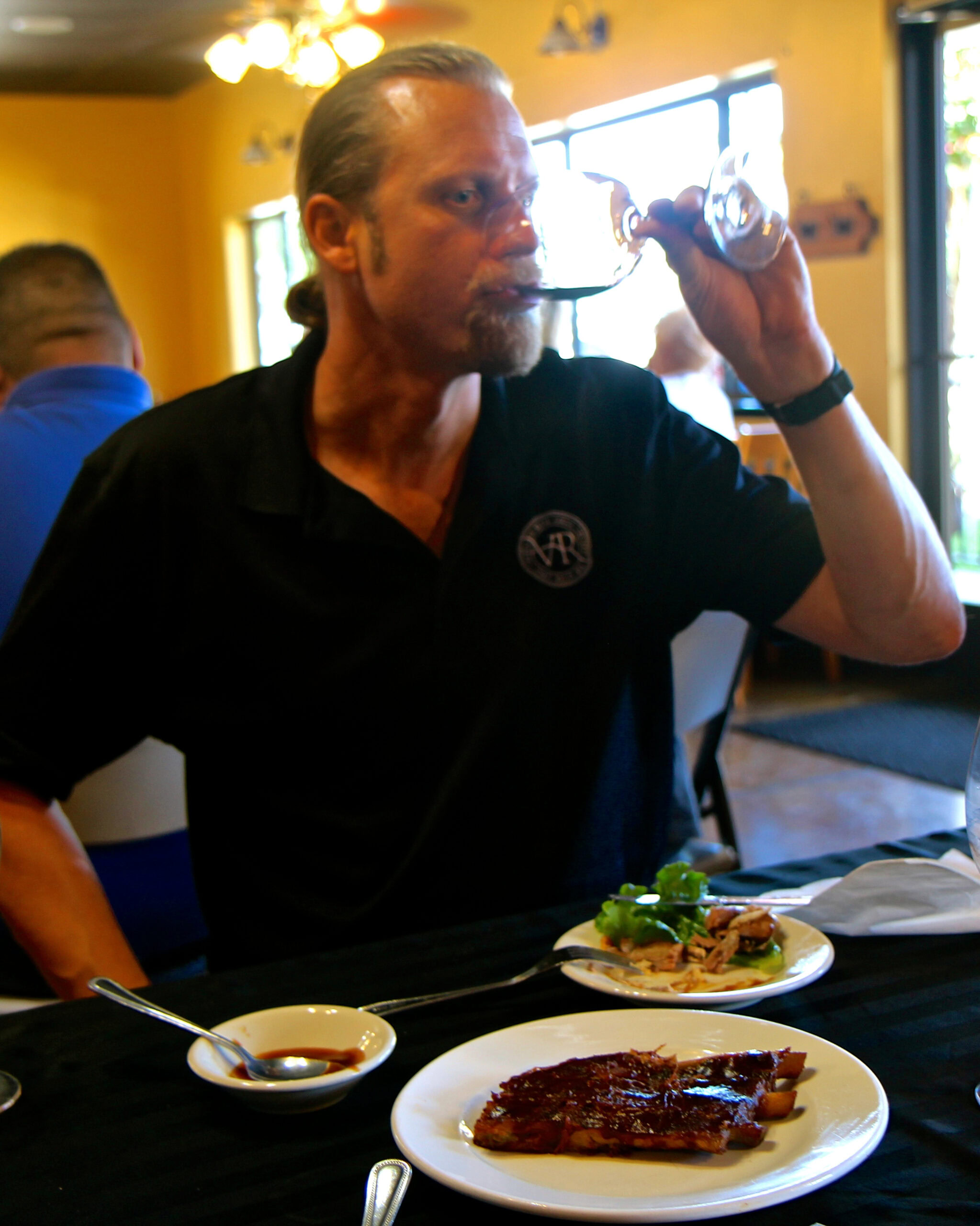 Man tasting wine at Lodi Winegrape Commission event, enjoying local wines and cuisine.