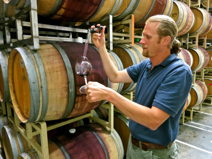 Man tasting wine in a barrel room at Lodi Winegrape Commission.