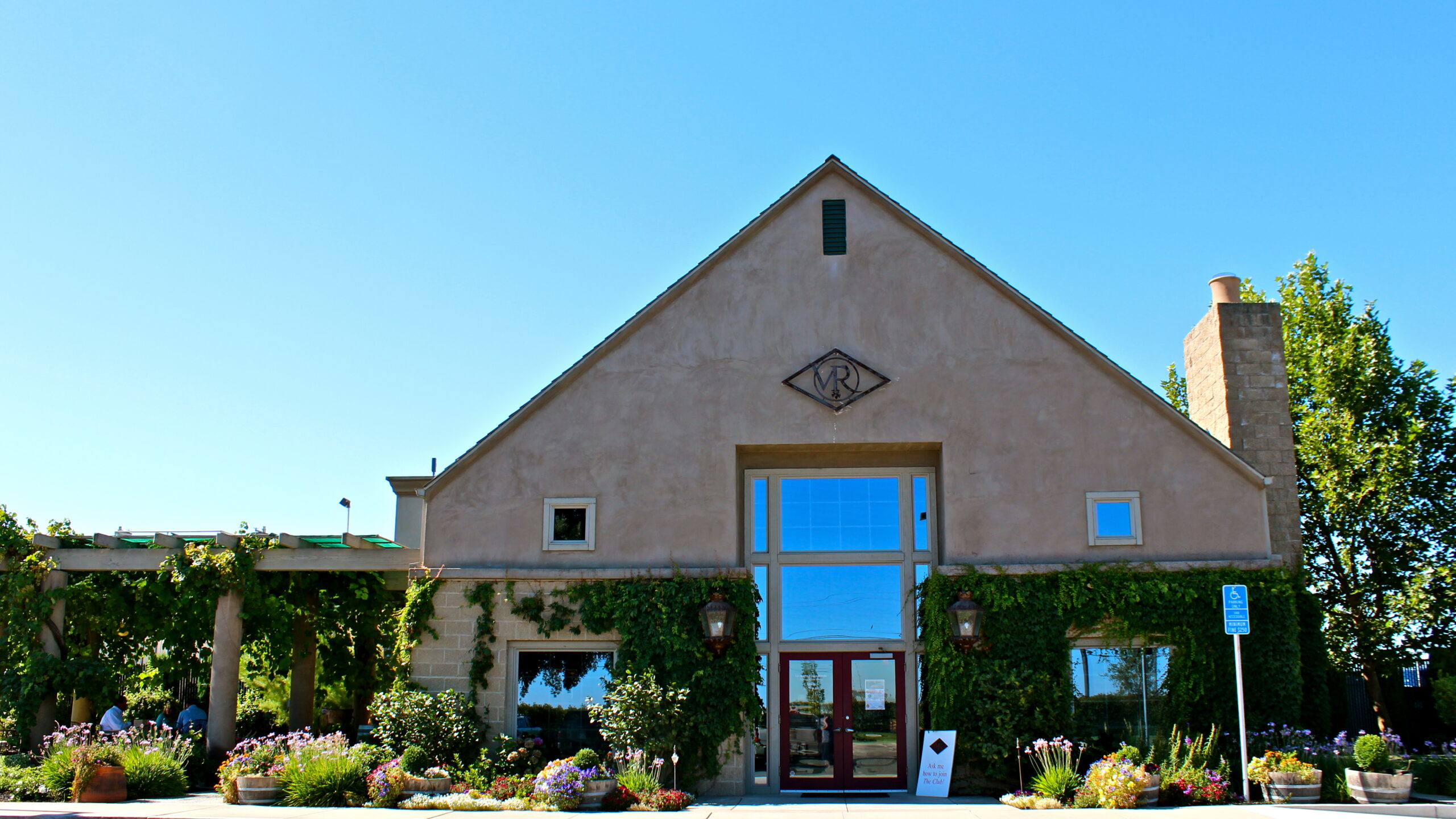 Lodi Winegrape Commission building with vineyard and garden in front, clear blue sky, and modern architecture.