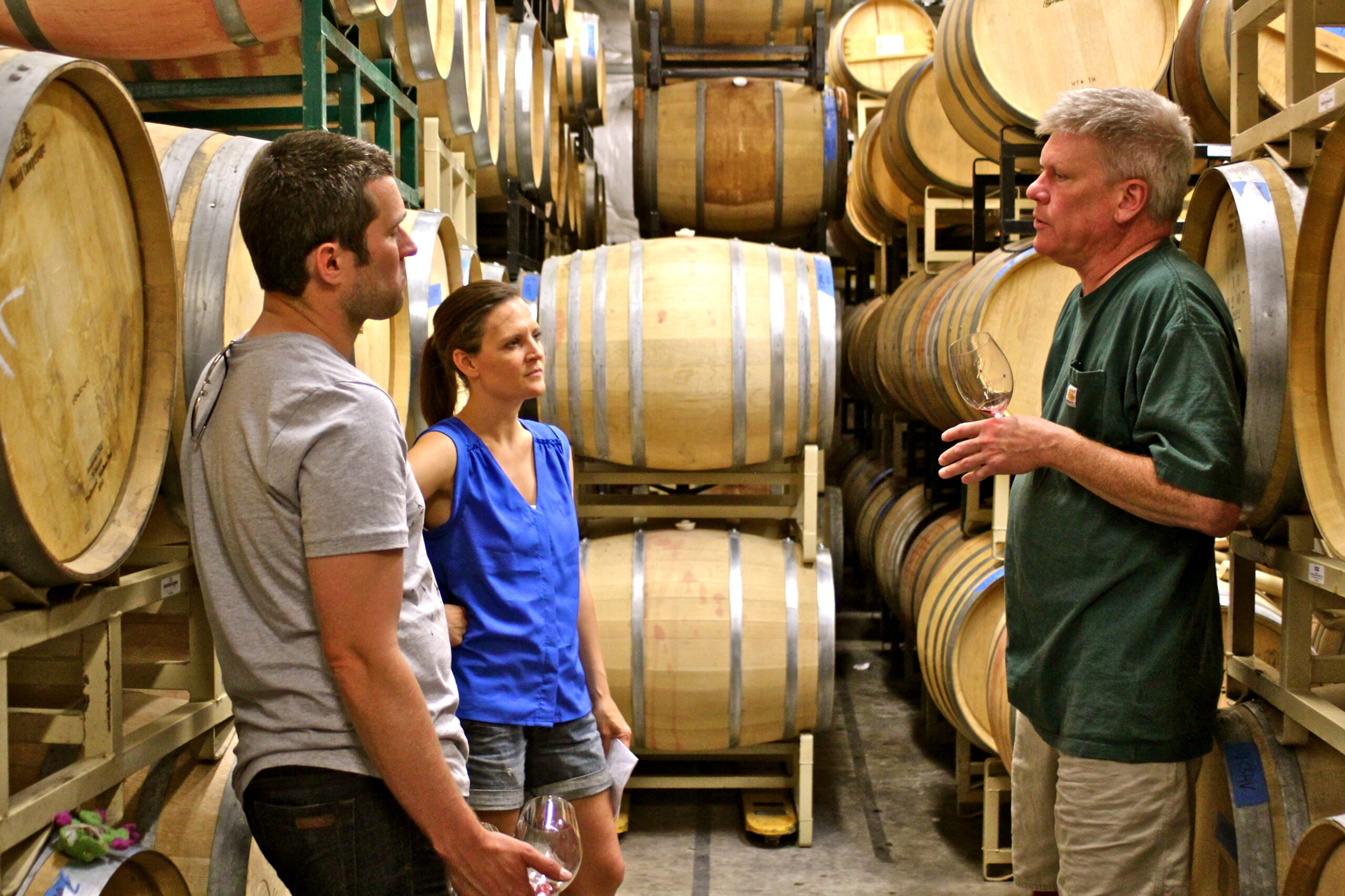 Wine expert explaining wine barrels to visitors at a winery in Lodi, California.