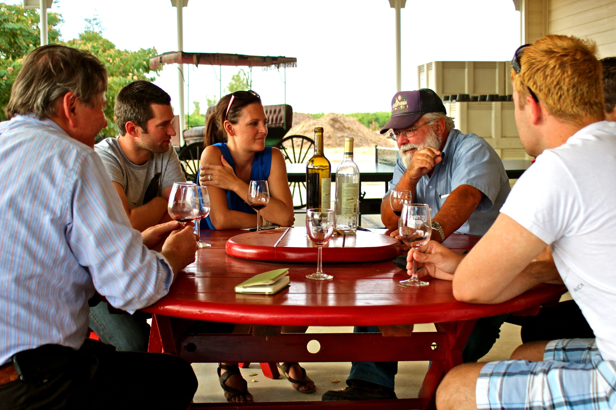 Group of people enjoying wine tasting outdoors at a vineyard in Lodi, California.