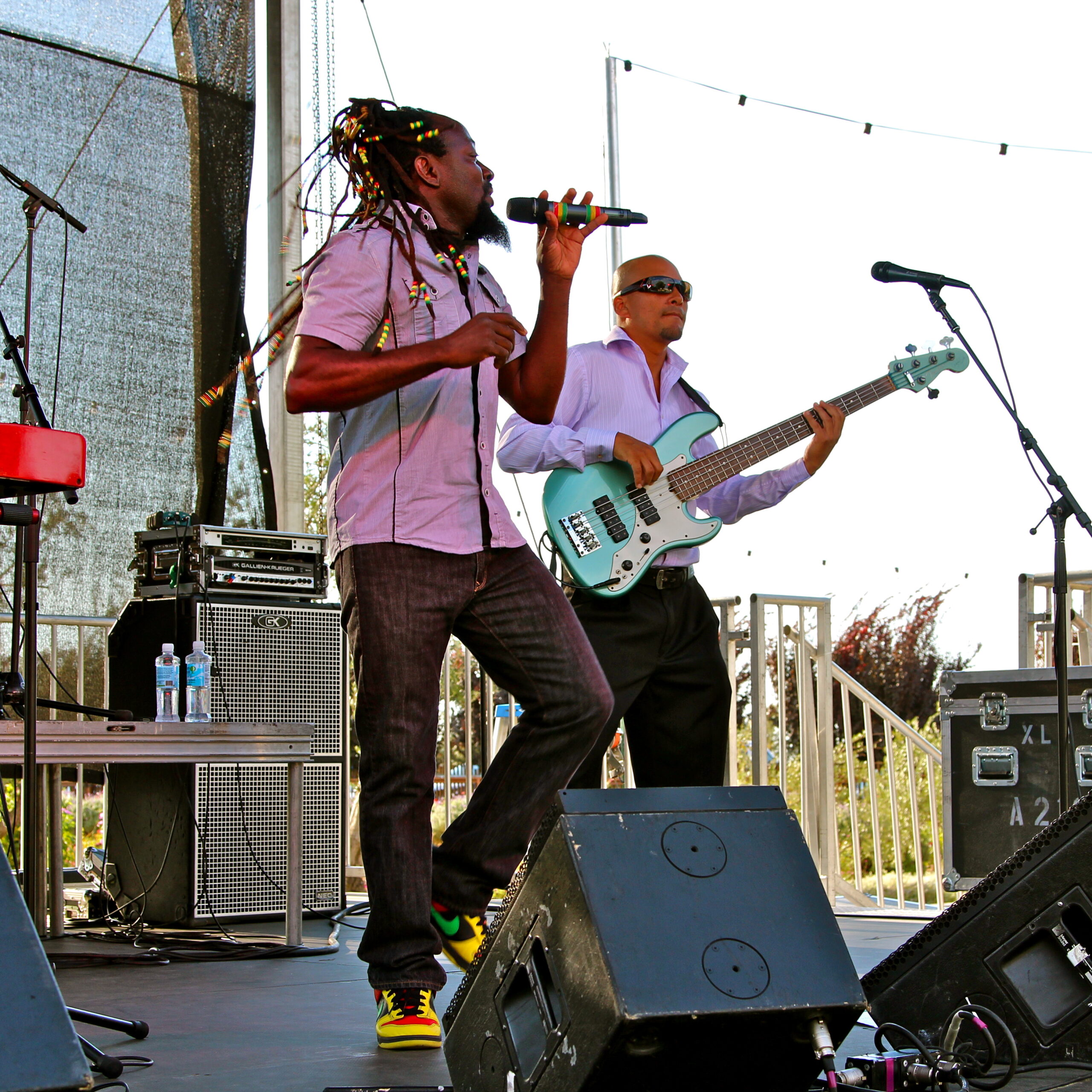 Musicians performing live on stage at a Lodi wine event, with a singer and bassist under outdoor string lights.