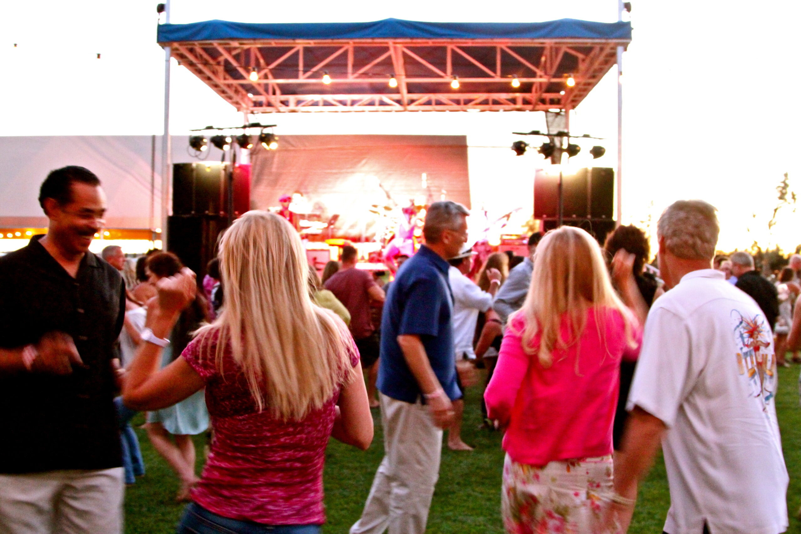 People dancing and enjoying music at a Lodi Winegrape Commission outdoor event.