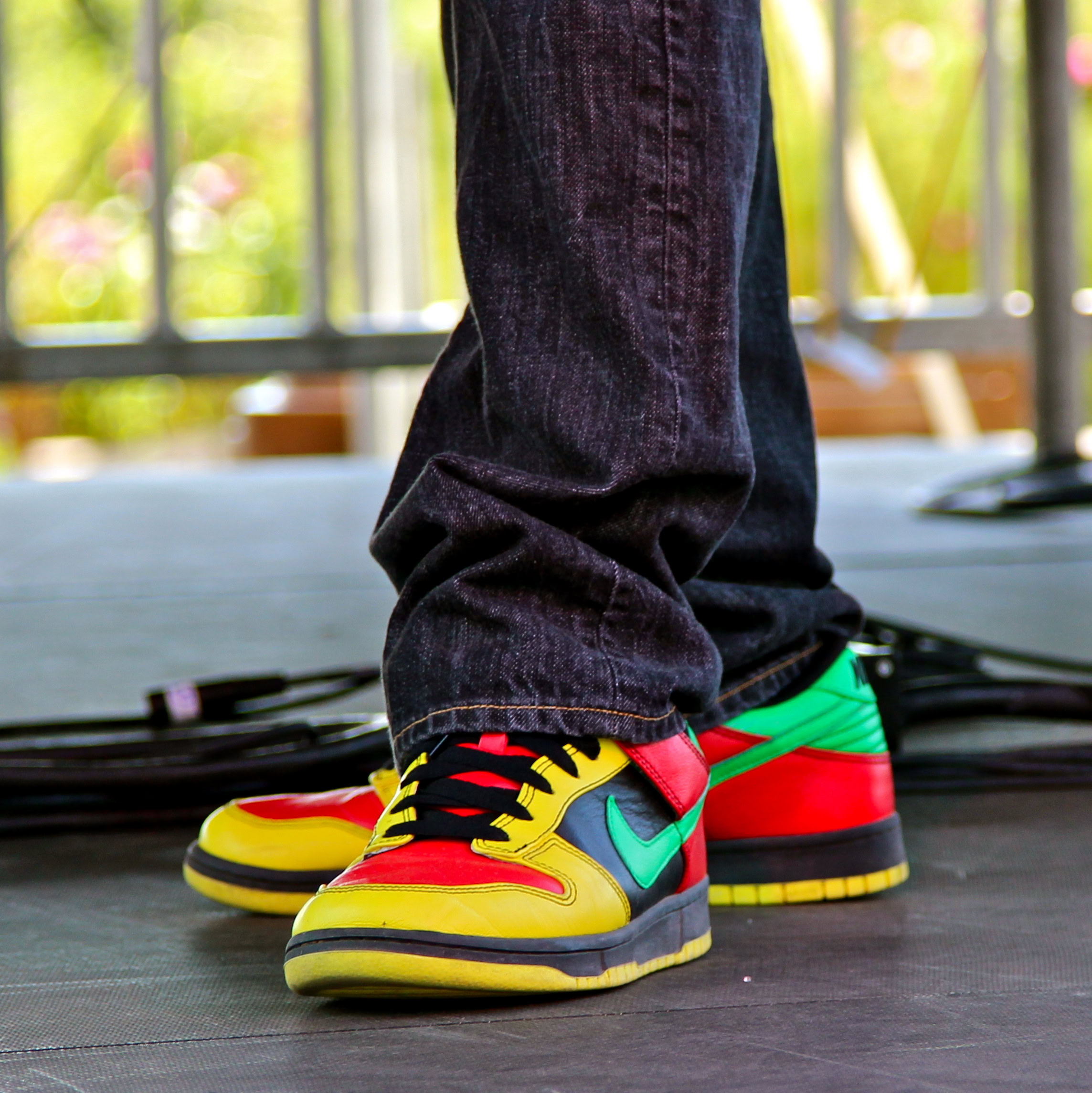 Brightly colored sneakers worn by a person on stage with a blurred background.