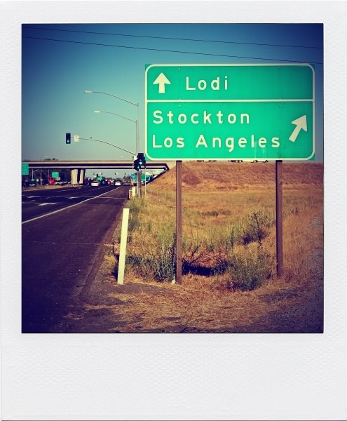 Road sign showing directions to Lodi, Stockton, and Los Angeles in California.
