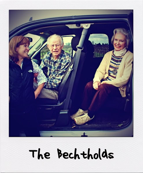 Three people enjoying a visit to a vineyard, with two sitting in a vehicle and one standing outside, smiling and engaging.