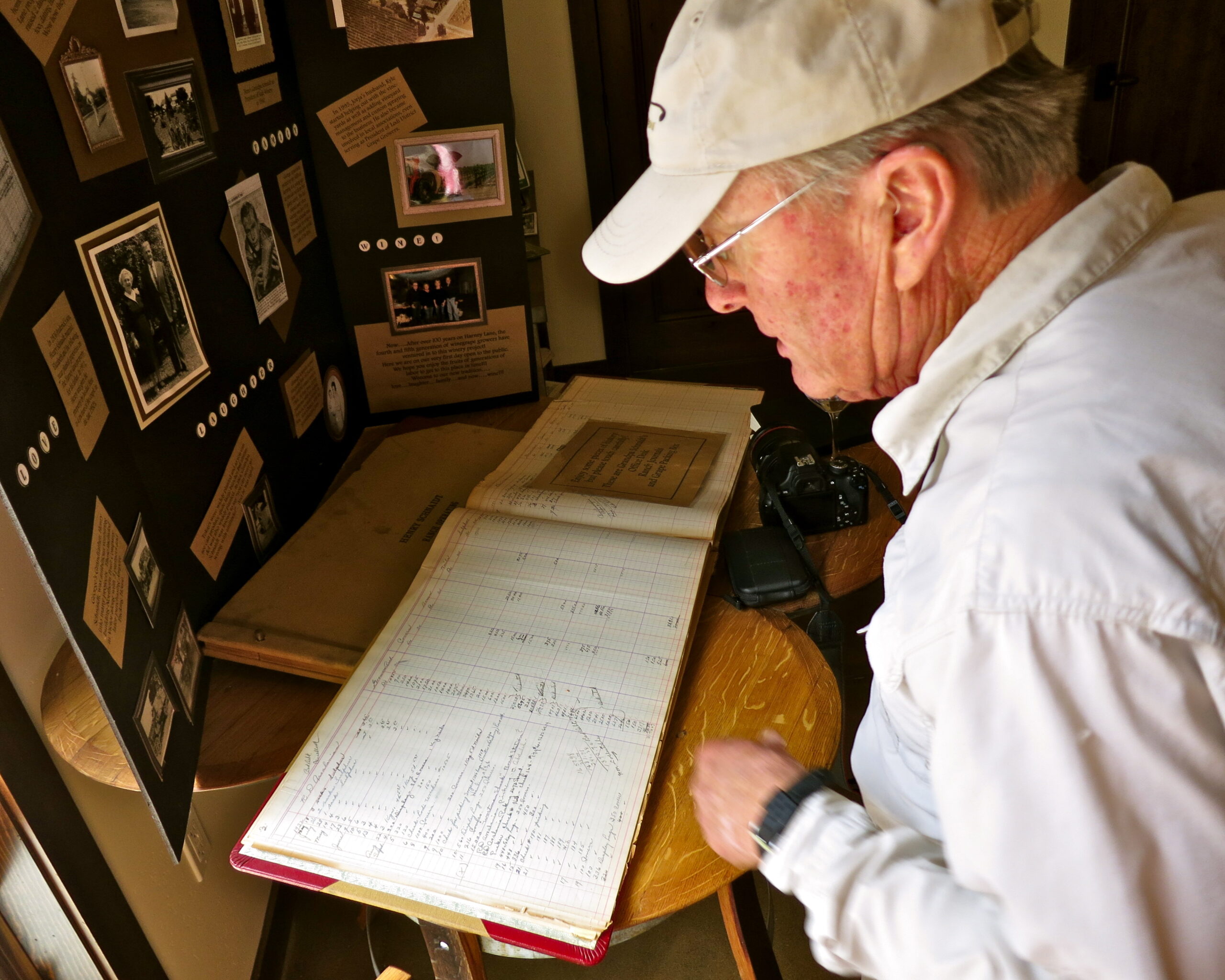 Man examining historical wine industry documents at Lodi Winegrape Commission exhibit.