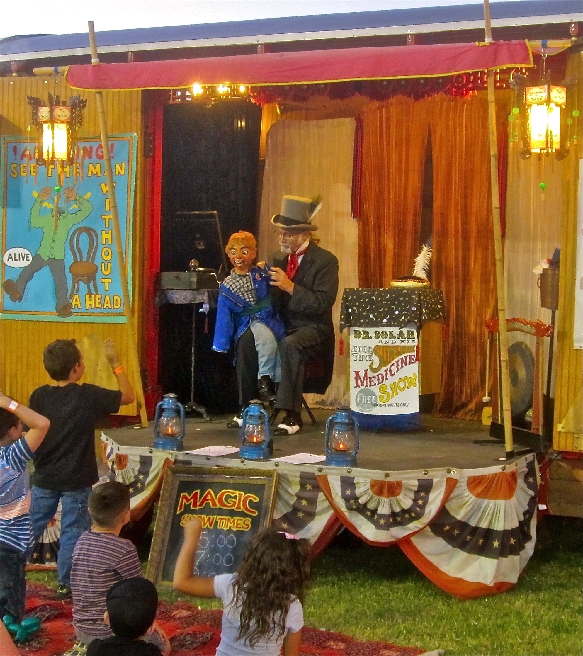 Performers on stage at Lodi Winegrape Commission event with children watching and colorful decorations.