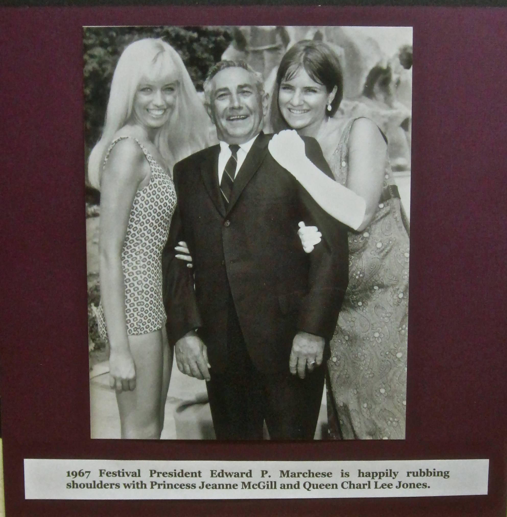 Black and white photo of three people smiling, celebrating at a festival, with a caption about 1967 event.