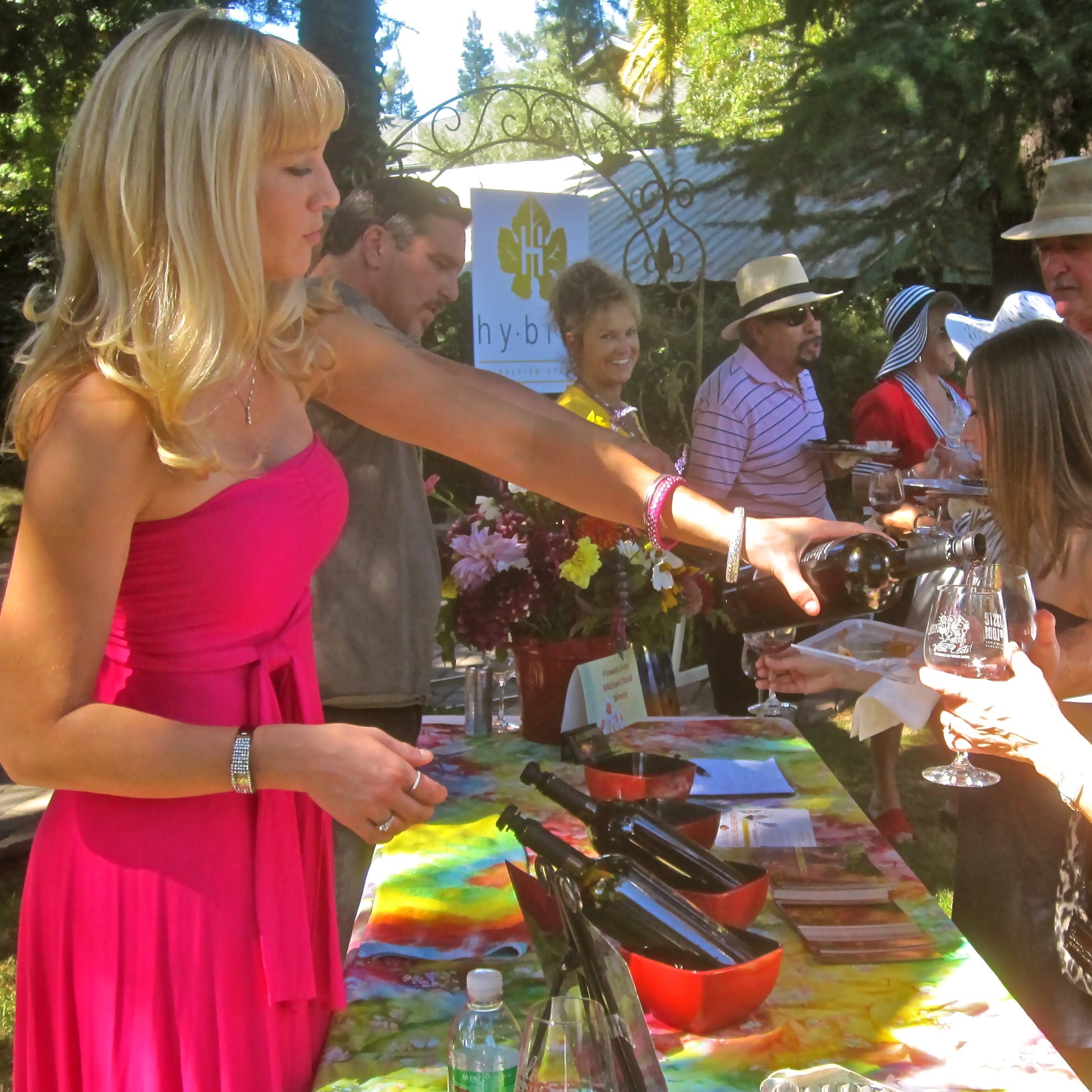 People enjoying wine tasting at Lodi Winegrape Commission event outdoors.