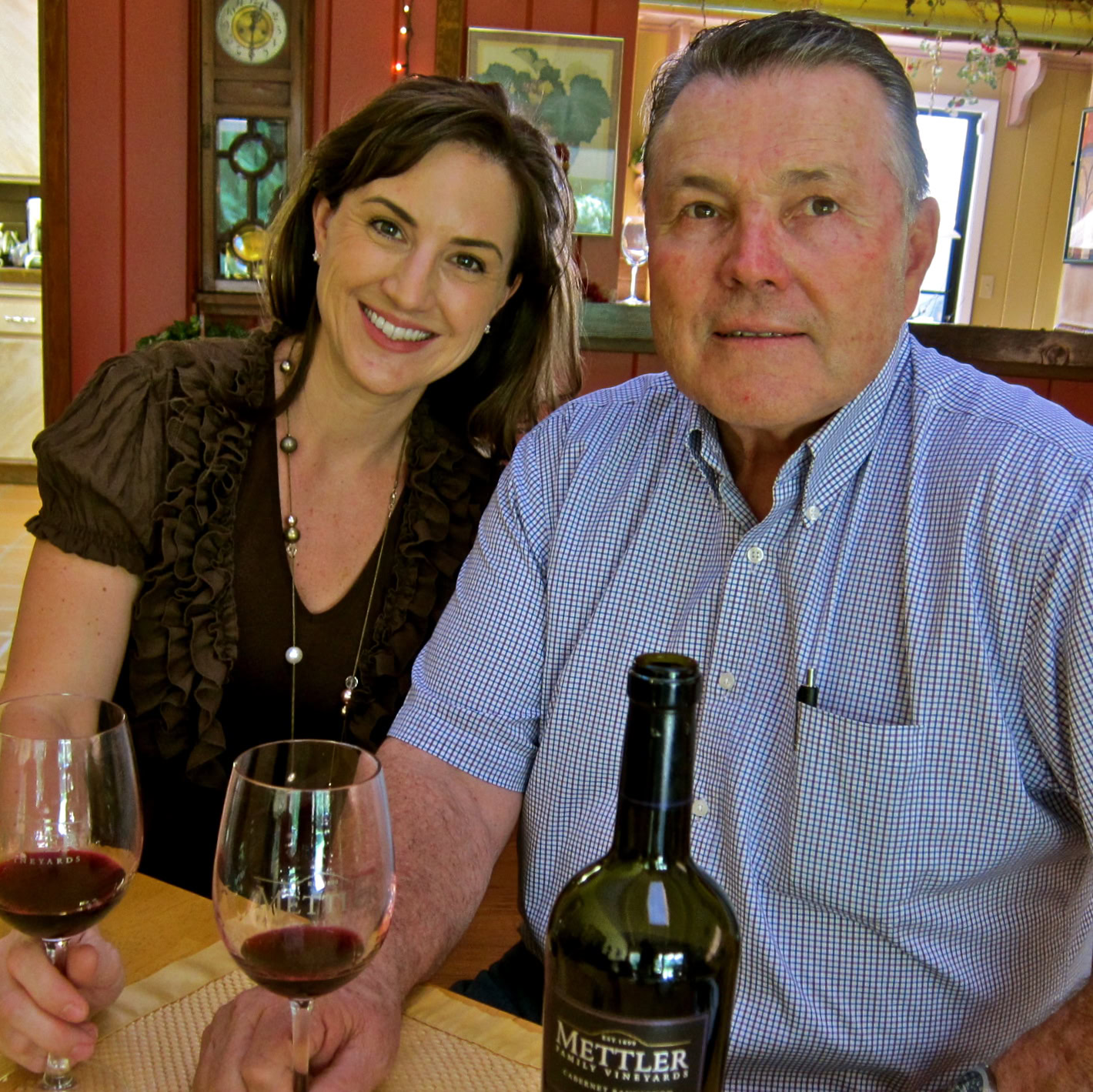 Smiling woman and man enjoying wine at Lodi winery, showcasing local wine culture.