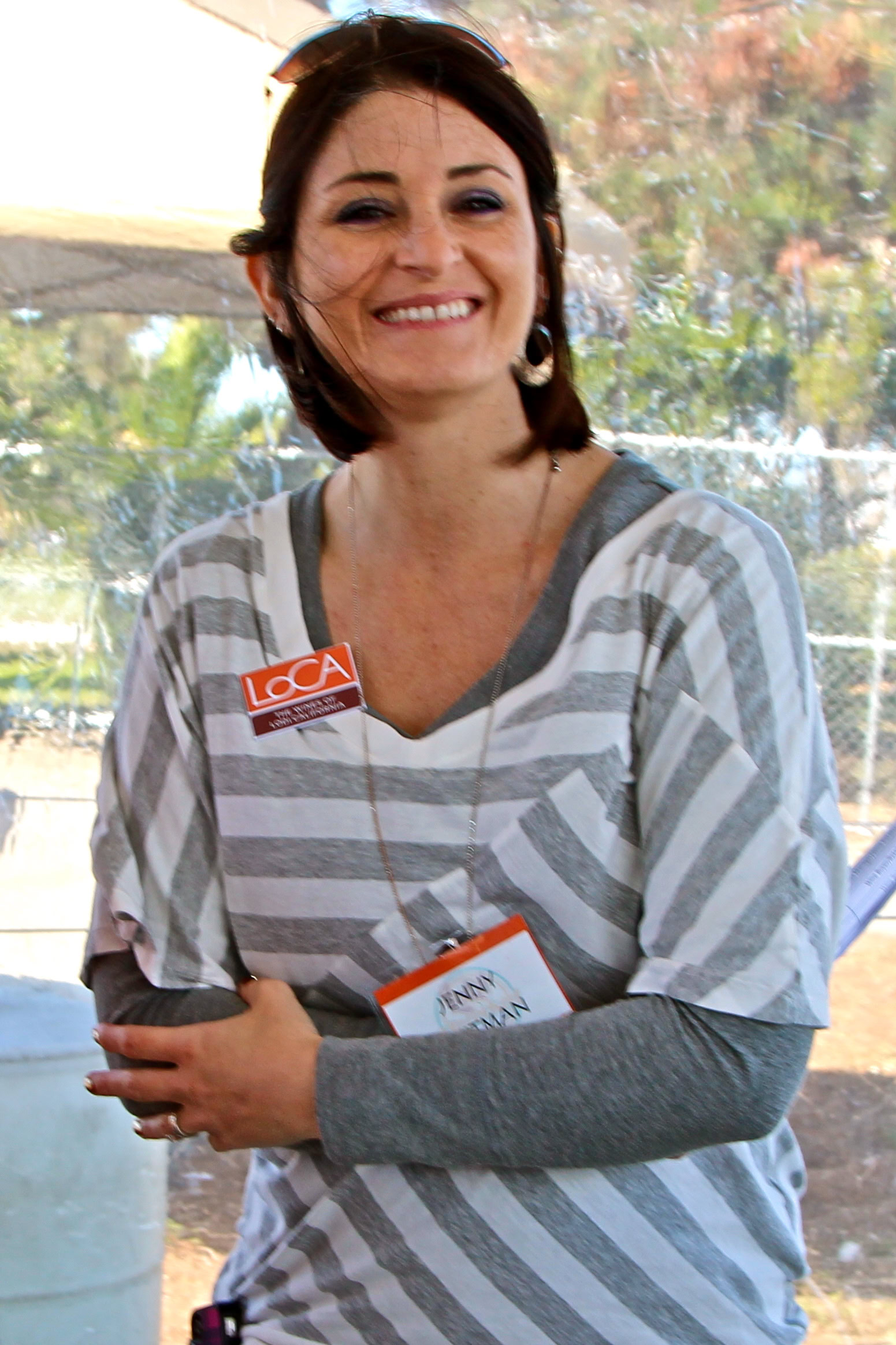 Smiling woman at Lodi Winegrape Commission event, wearing striped shirt and name badge, outdoors.