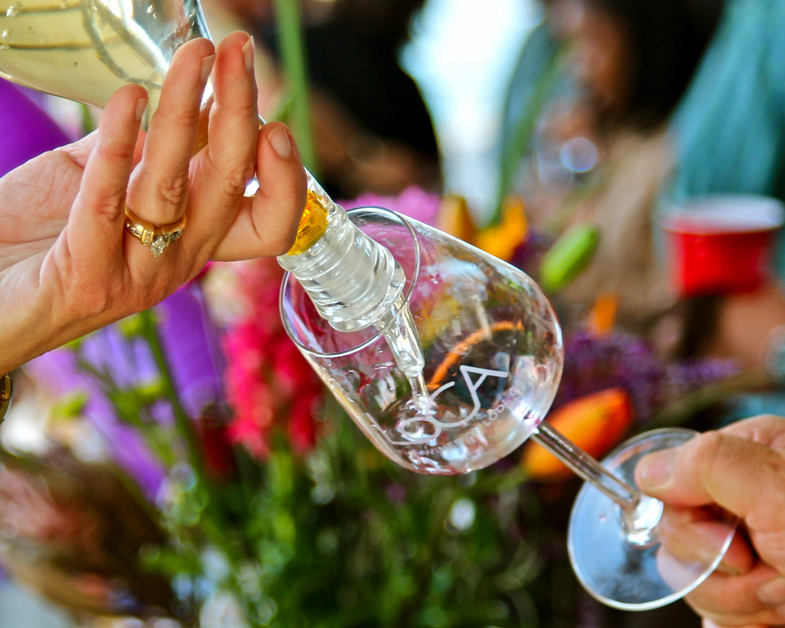 Person pouring wine into a glass at a Lodi wine event, showcasing wine culture and local vineyards.